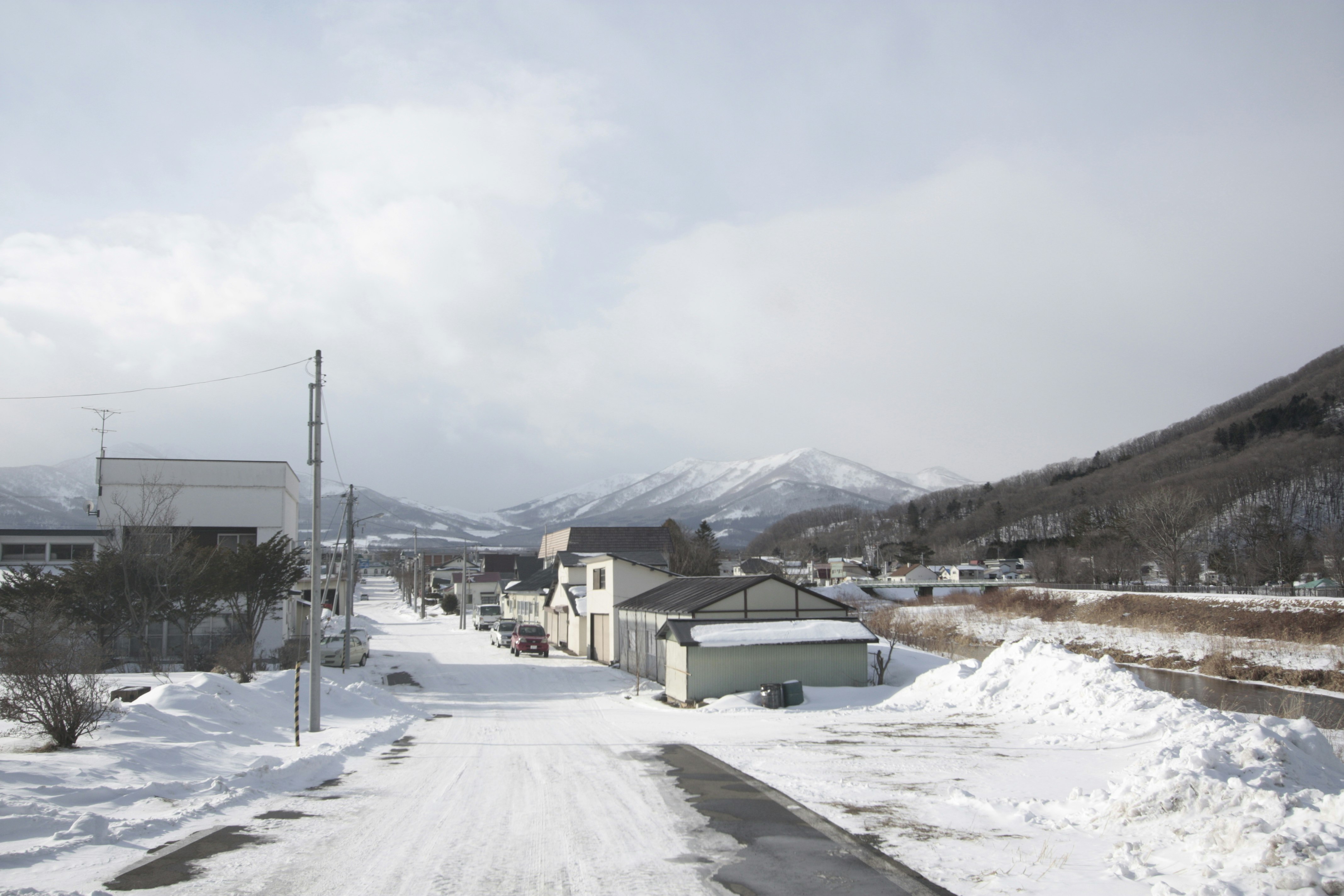 雪の積もった田舎の一本道と家並み