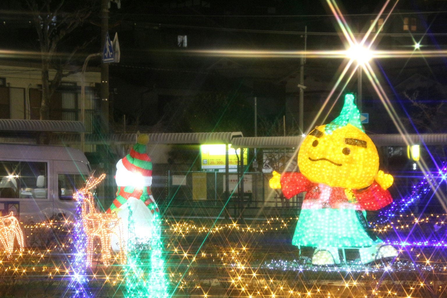 Personaggi illuminati colorati in un contesto notturno con luci festive