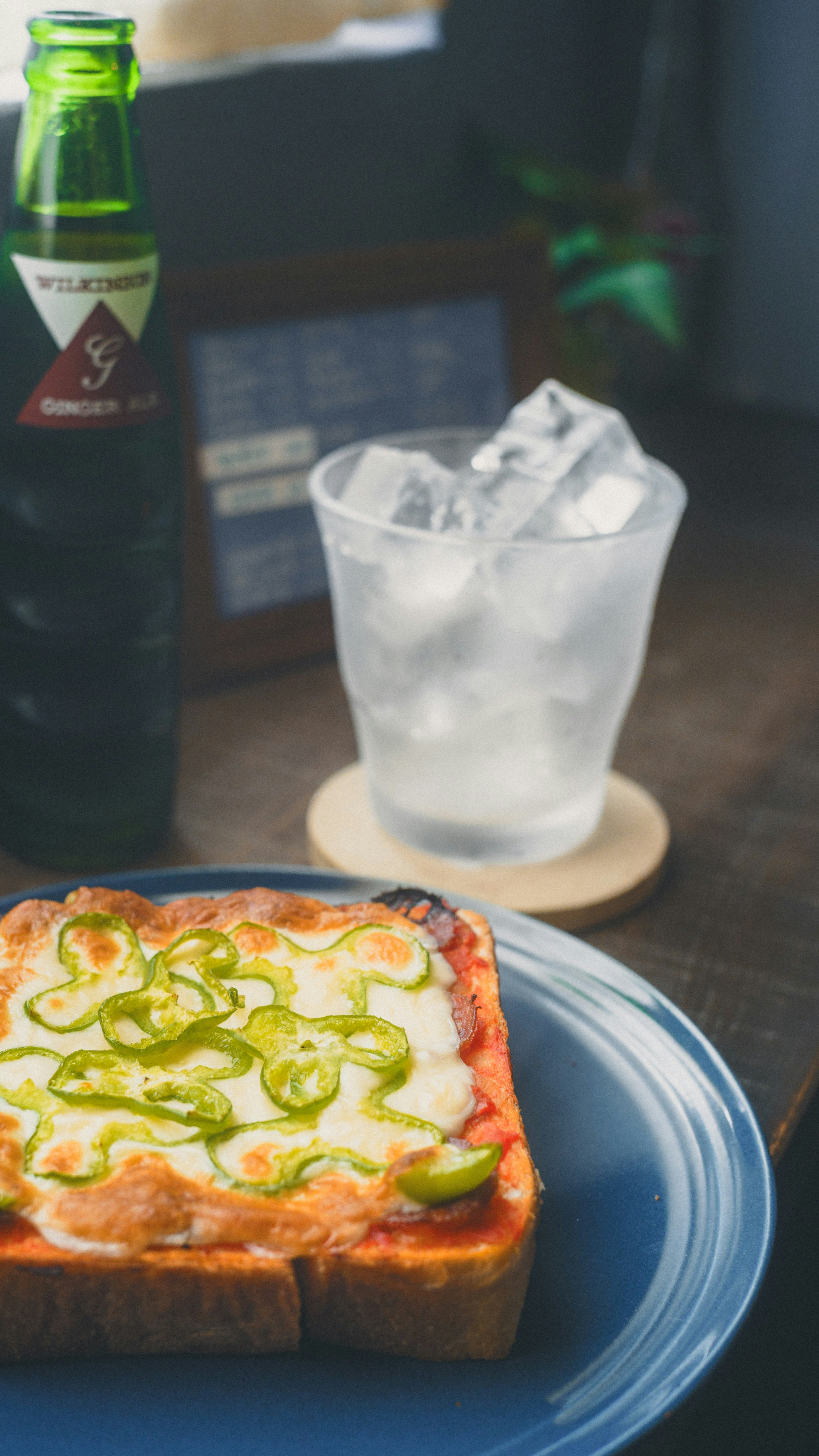 グラスの氷とピザのあるカフェテーブル
