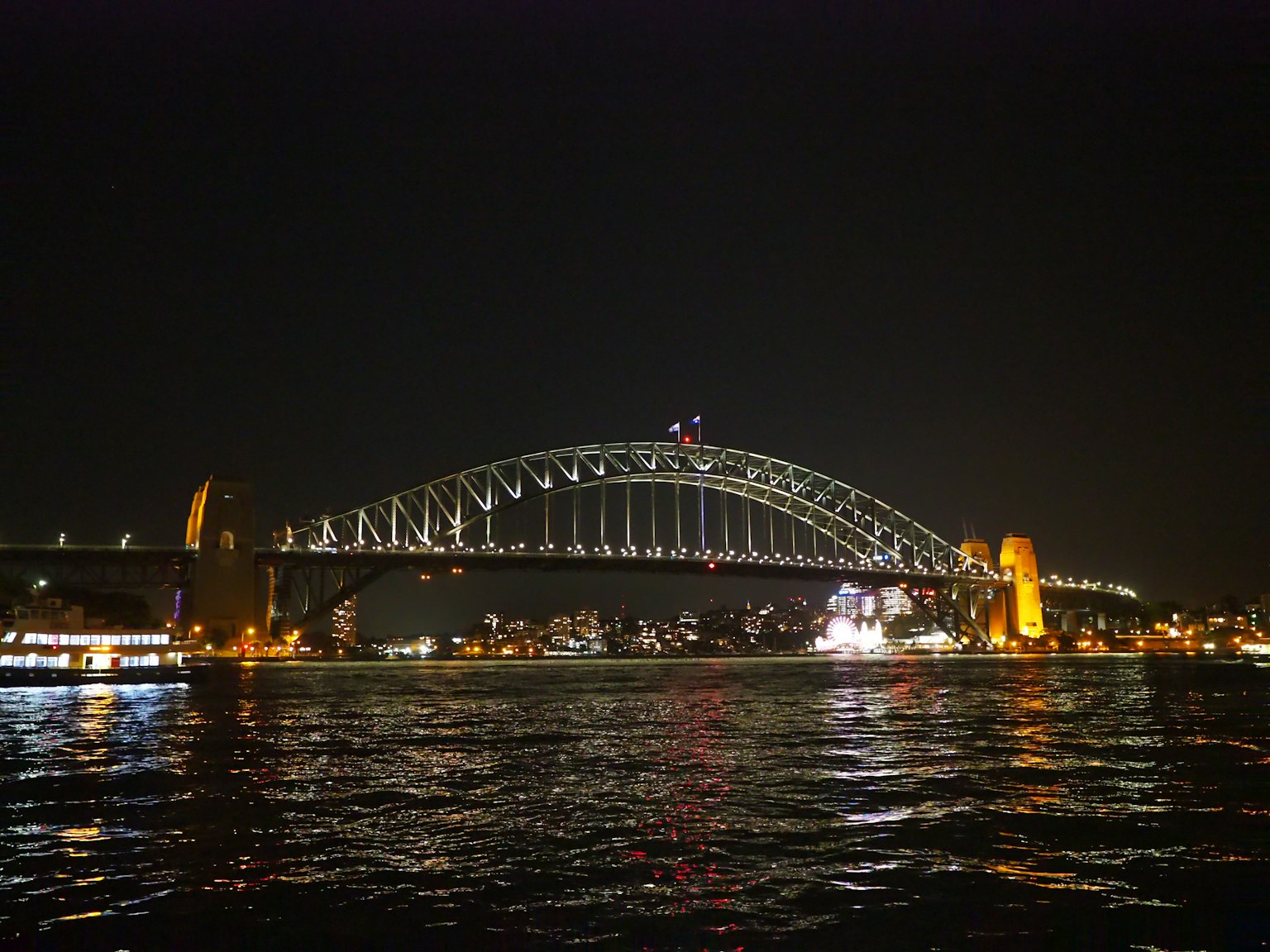 Beautiful view of Sydney Harbour Bridge at night with reflections on the water