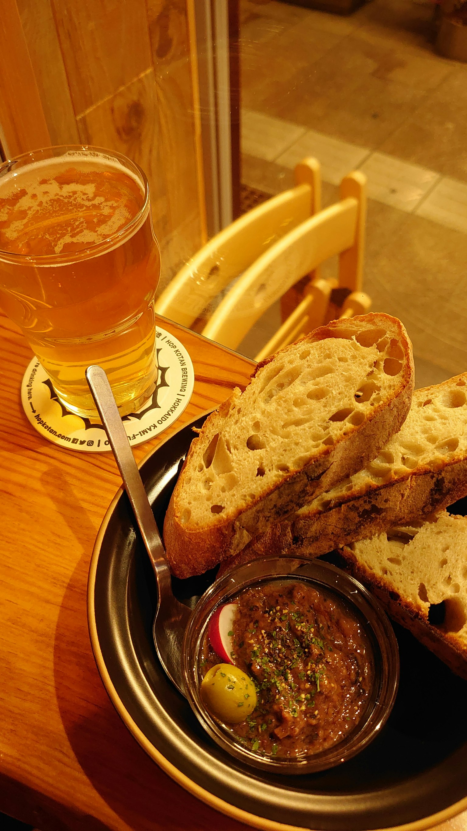 Une assiette de pain avec une trempette et un verre de bière