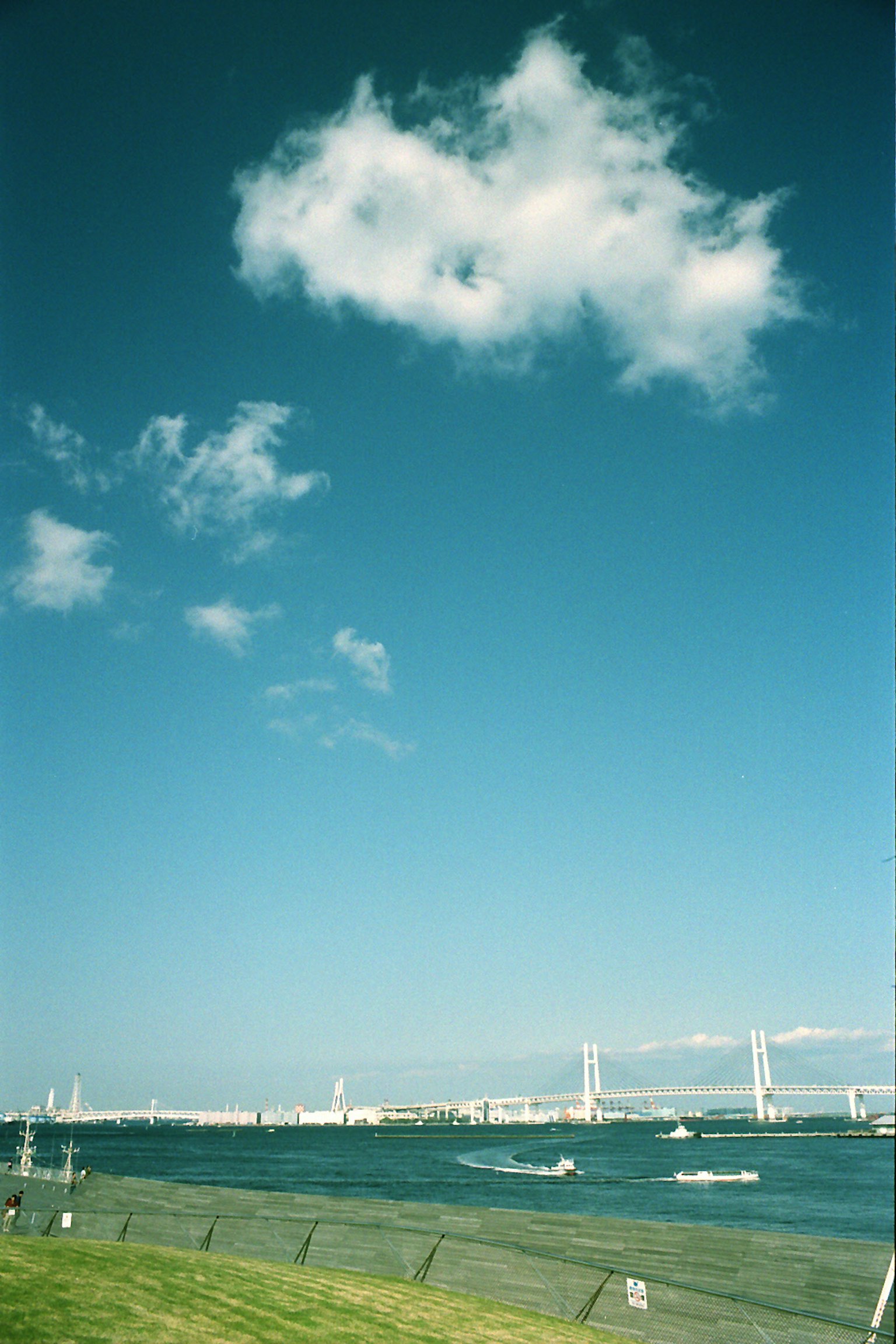 Vista escénica con cielo azul y nubes río y puente al fondo