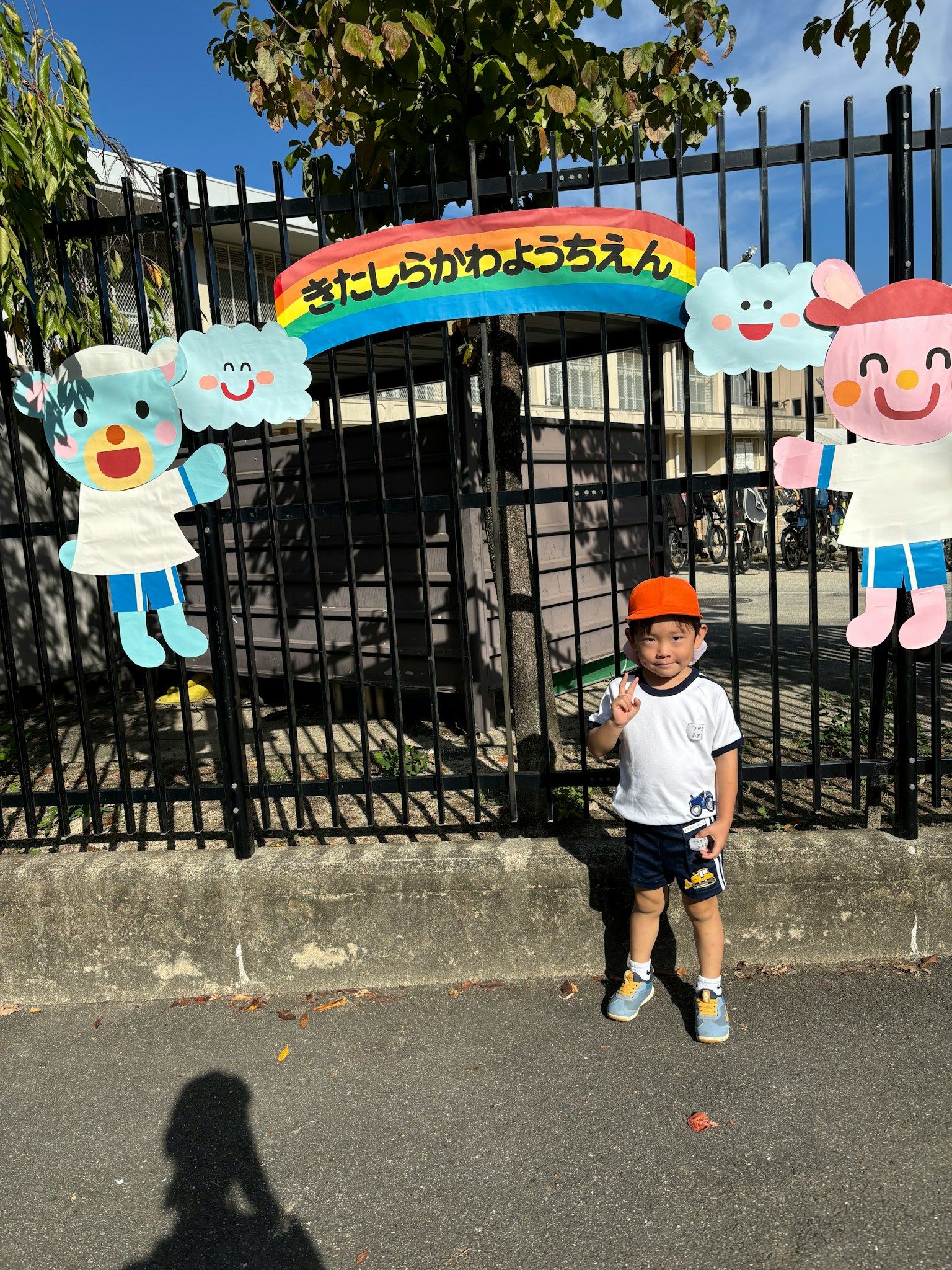 Un bambino che sta davanti a decorazioni colorate in un parco
