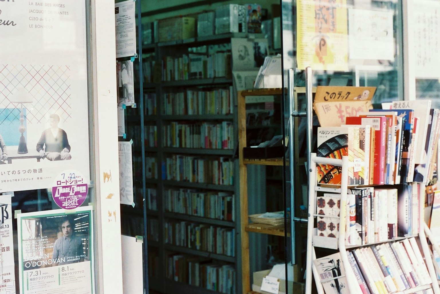 Außenansicht einer Buchhandlung mit Bücherregalen, die durch eine Glastür sichtbar sind