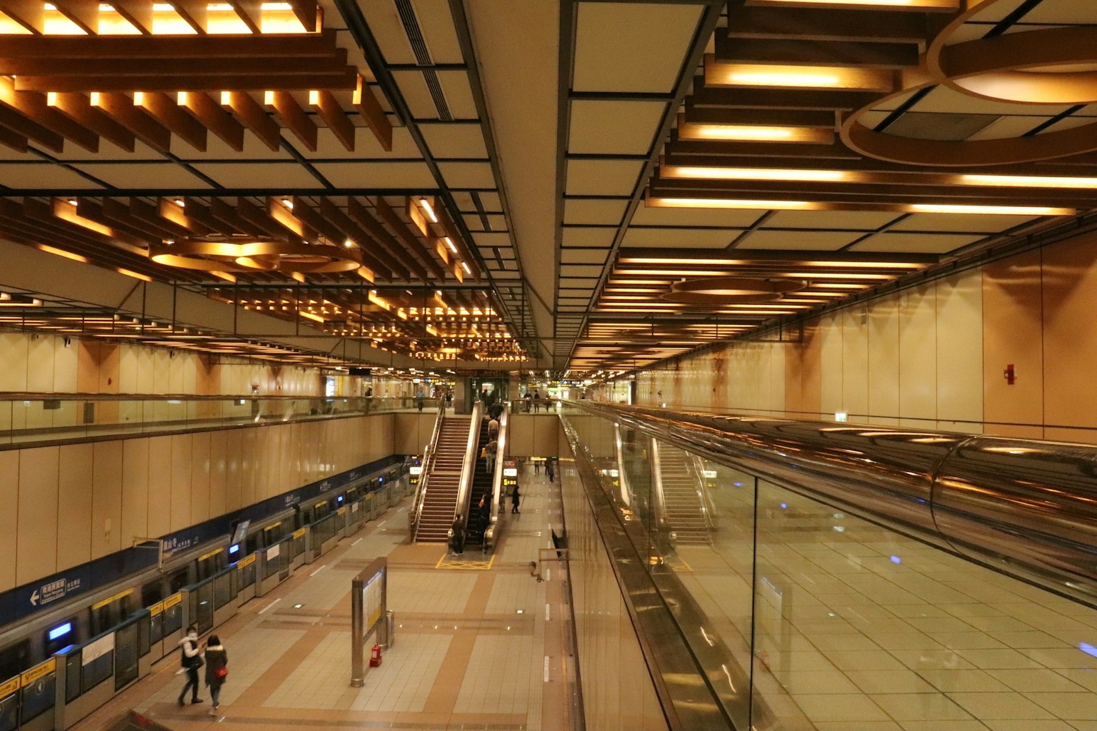 Modernes Innendesign eines Flughafens mit silbernen Rolltreppen und Holzdekorationen