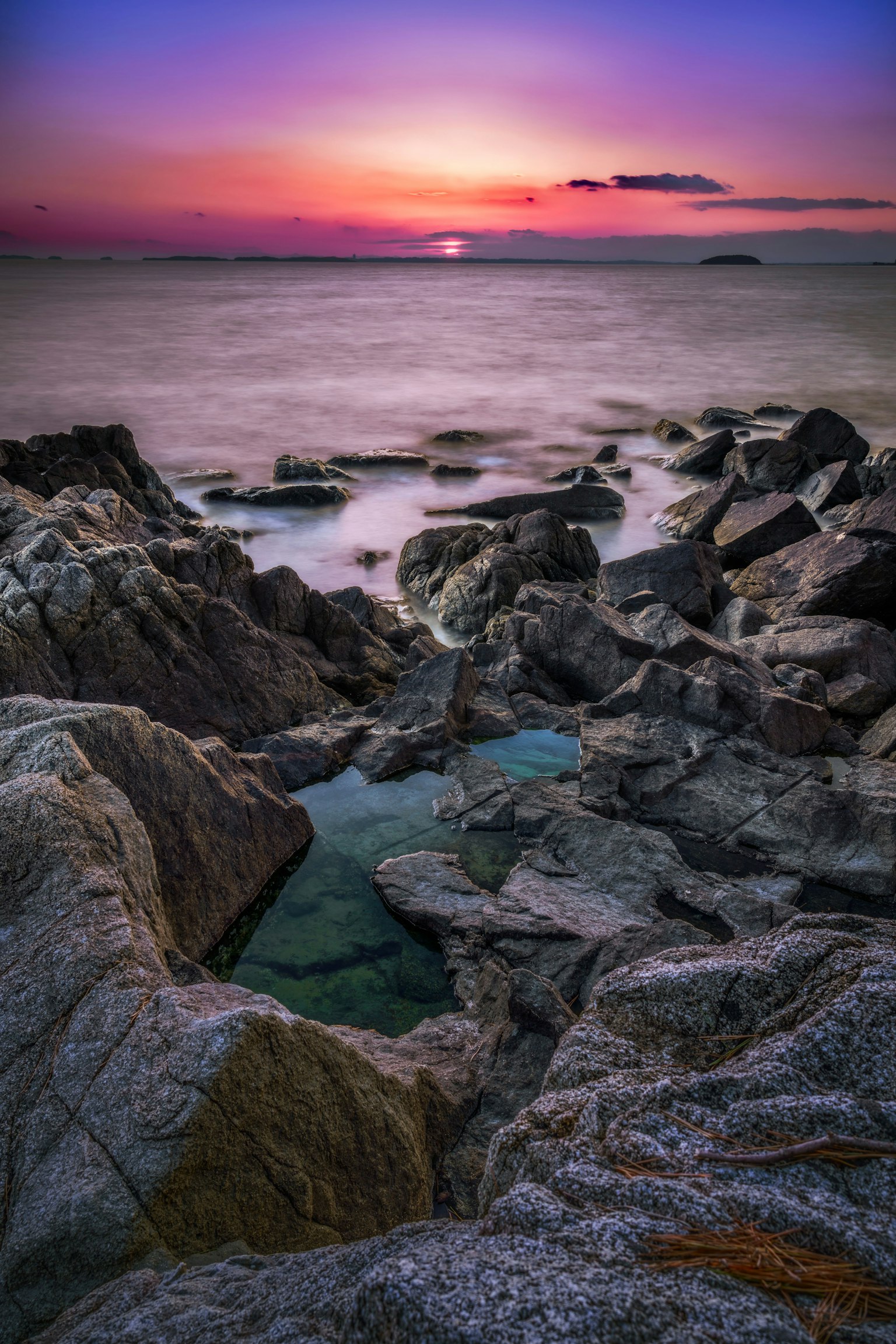 Magnifique coucher de soleil sur une côte rocheuse avec des eaux calmes
