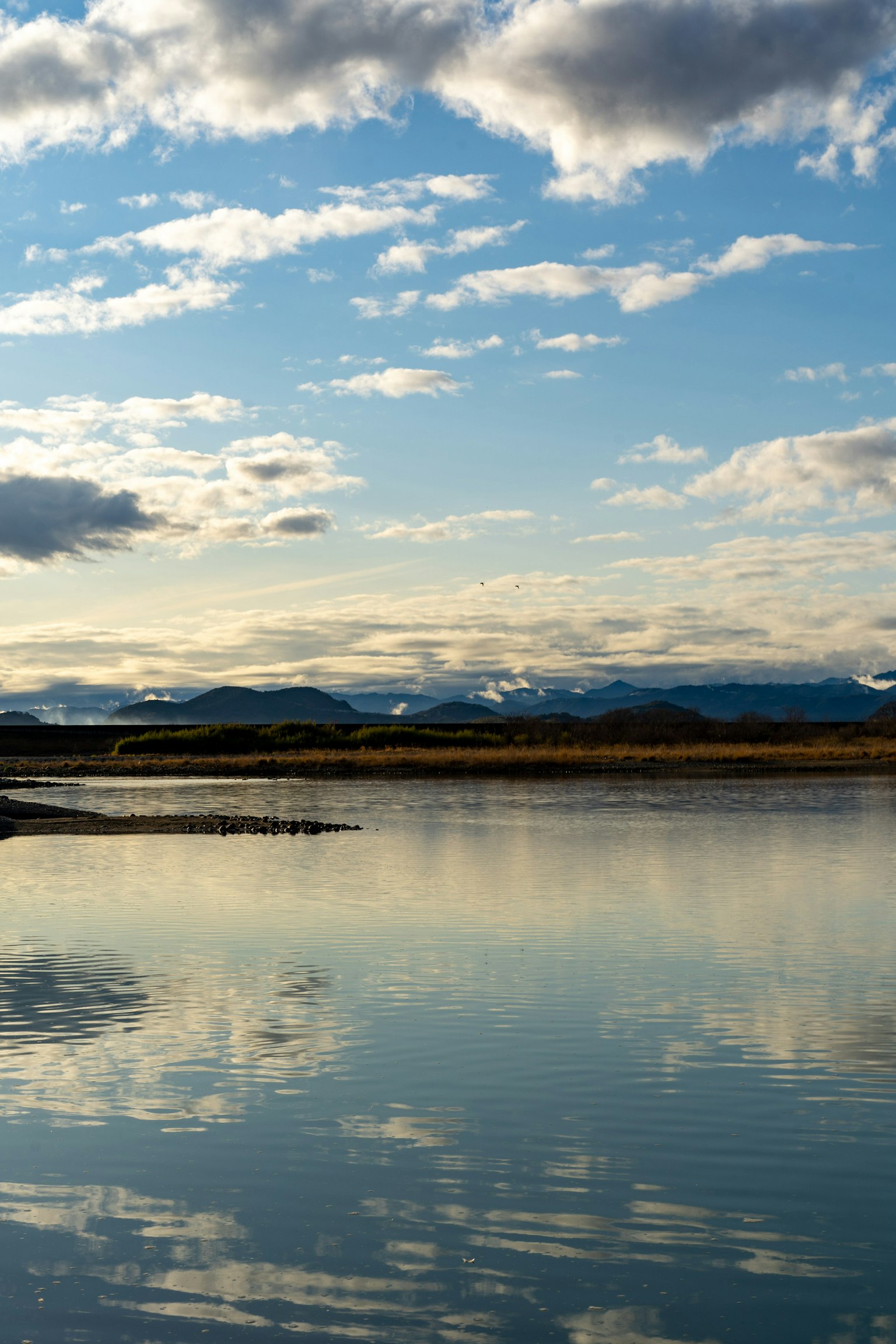 Lac calme reflétant des montagnes et le ciel