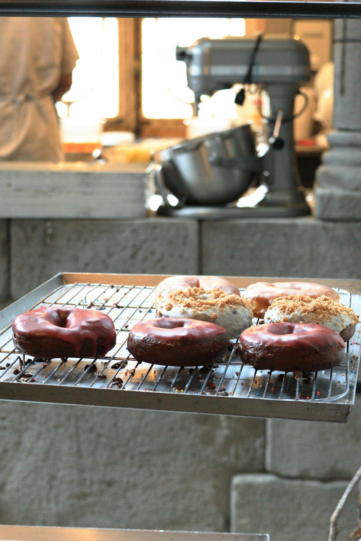 Donas recién horneadas en una rejilla en un entorno de cocina