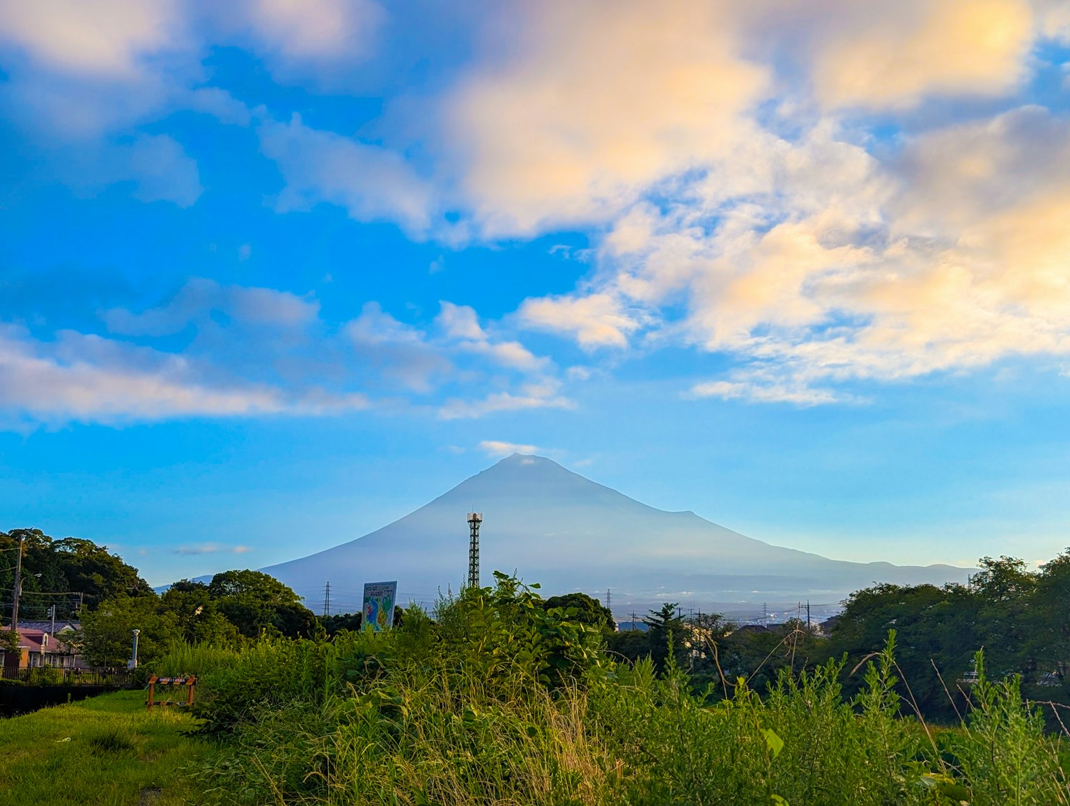美しい富士山の風景青い空と雲の下で緑の草原が広がる