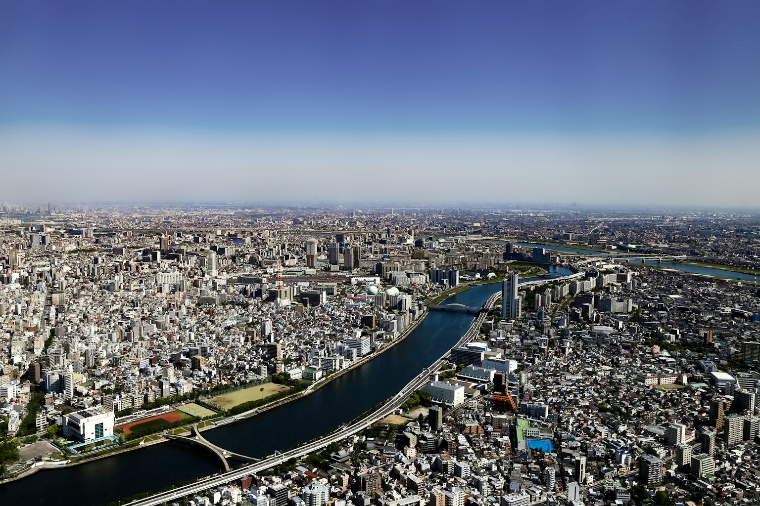 ภาพถ่ายทางอากาศของภูมิทัศน์เมืองขนาดใหญ่ของโตเกียวและแม่น้ำที่ไหล
