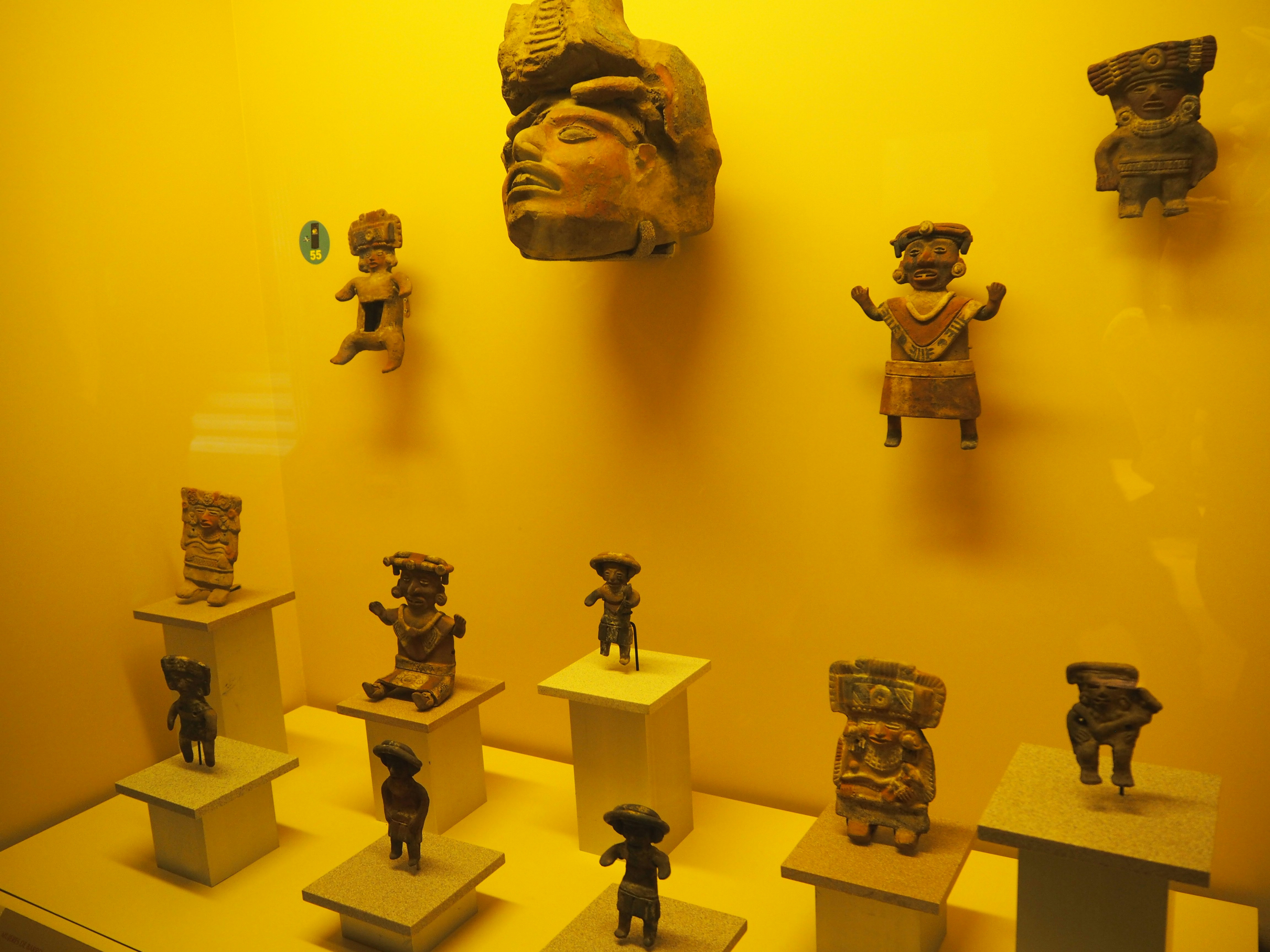 黄色い展示室に並ぶ小さな仏像フィギュア
