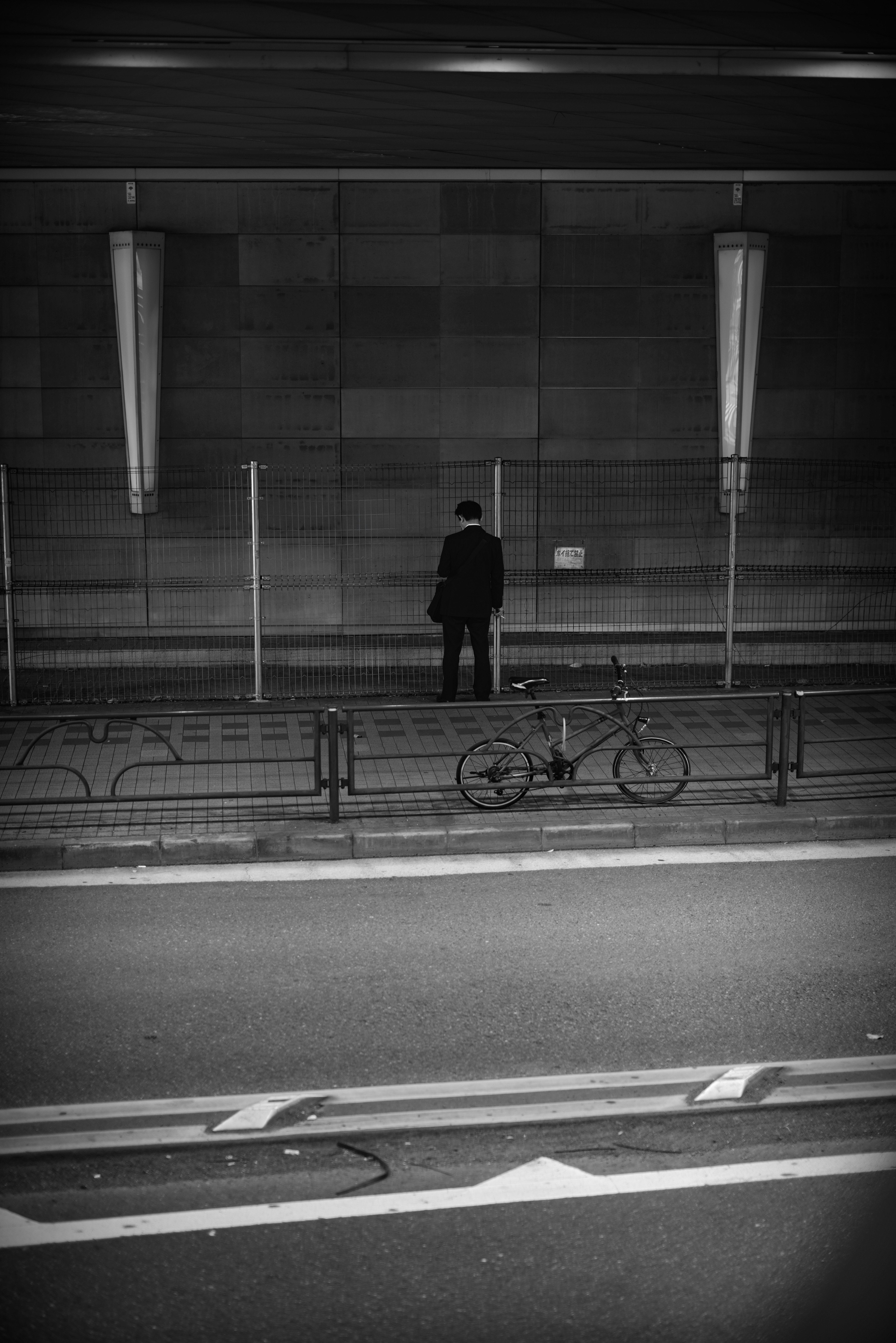 乃木坂トンネルの壁沿いに並ぶ自転車と人影