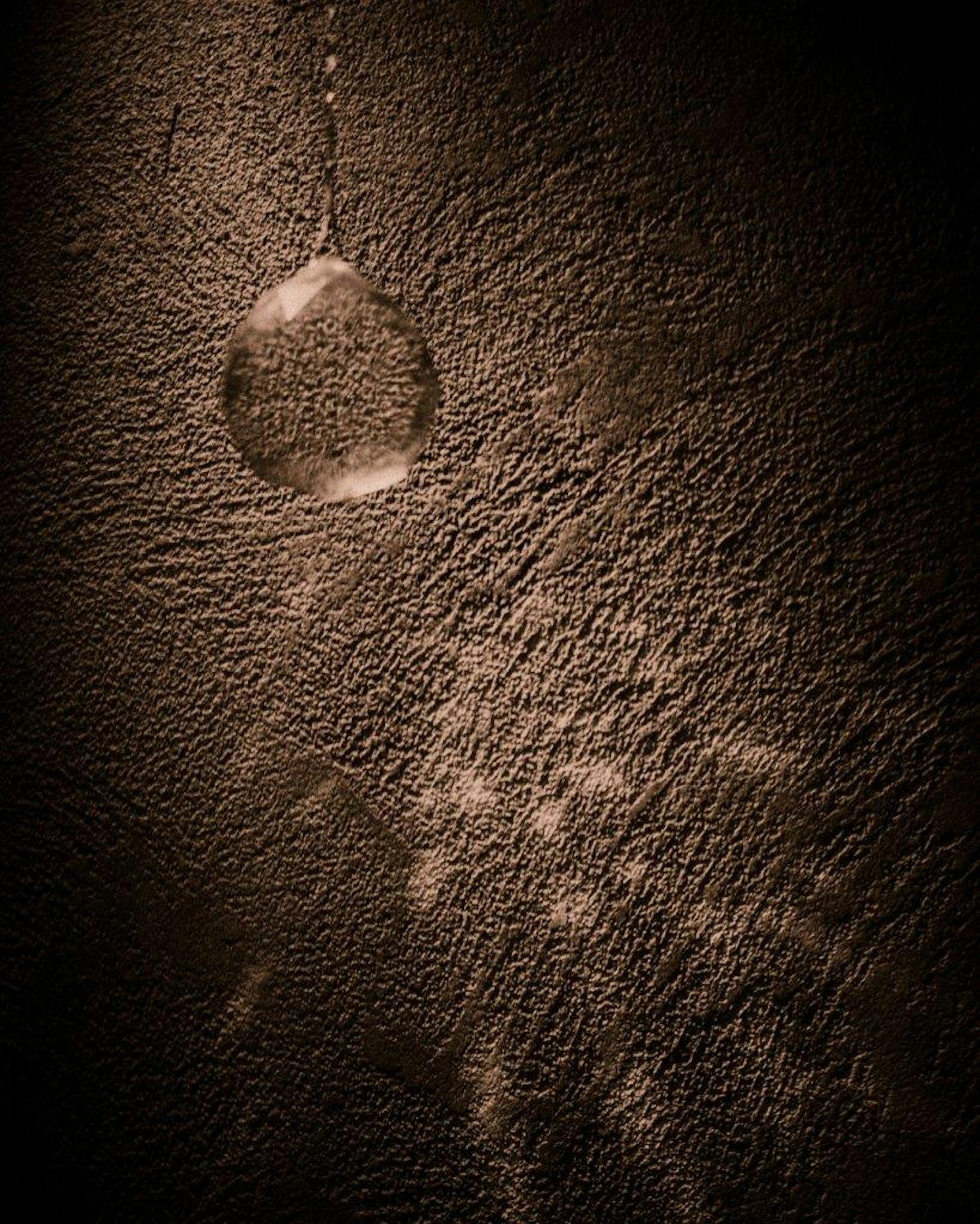 Sphère translucide projetant une ombre sur un mur texturé