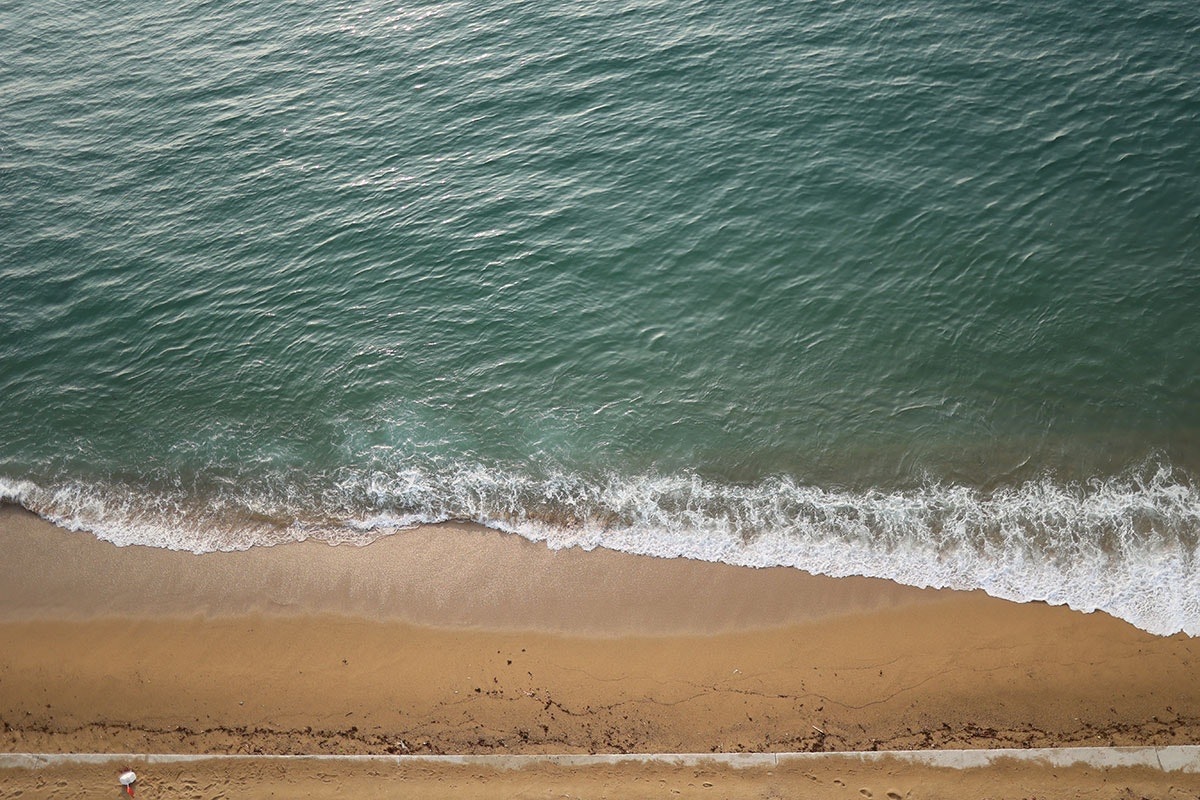 Sandy beach shoreline with ocean waves