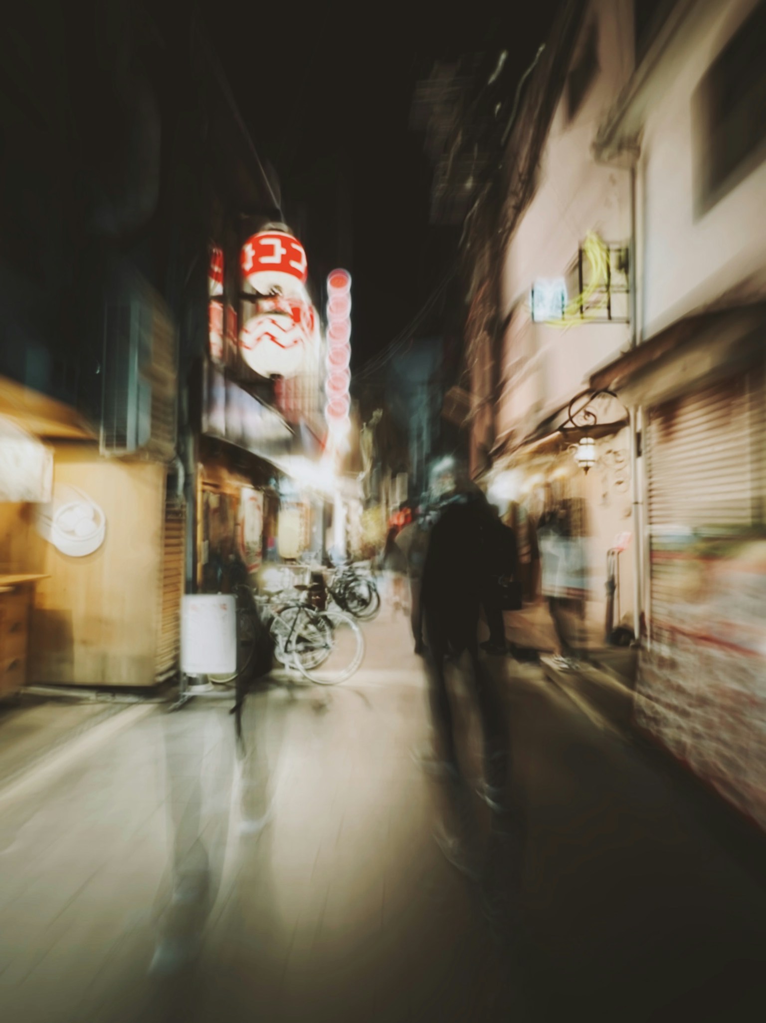 Verschwommene Straßenszene bei Nacht mit Fußgängern und Neonlichtern
