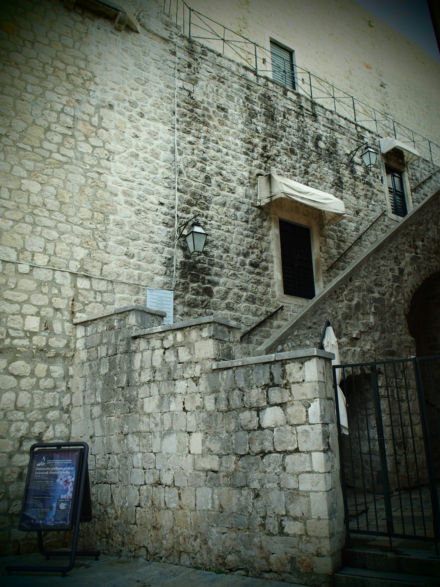 Edificio de piedra con escaleras y puerta en una calle antigua