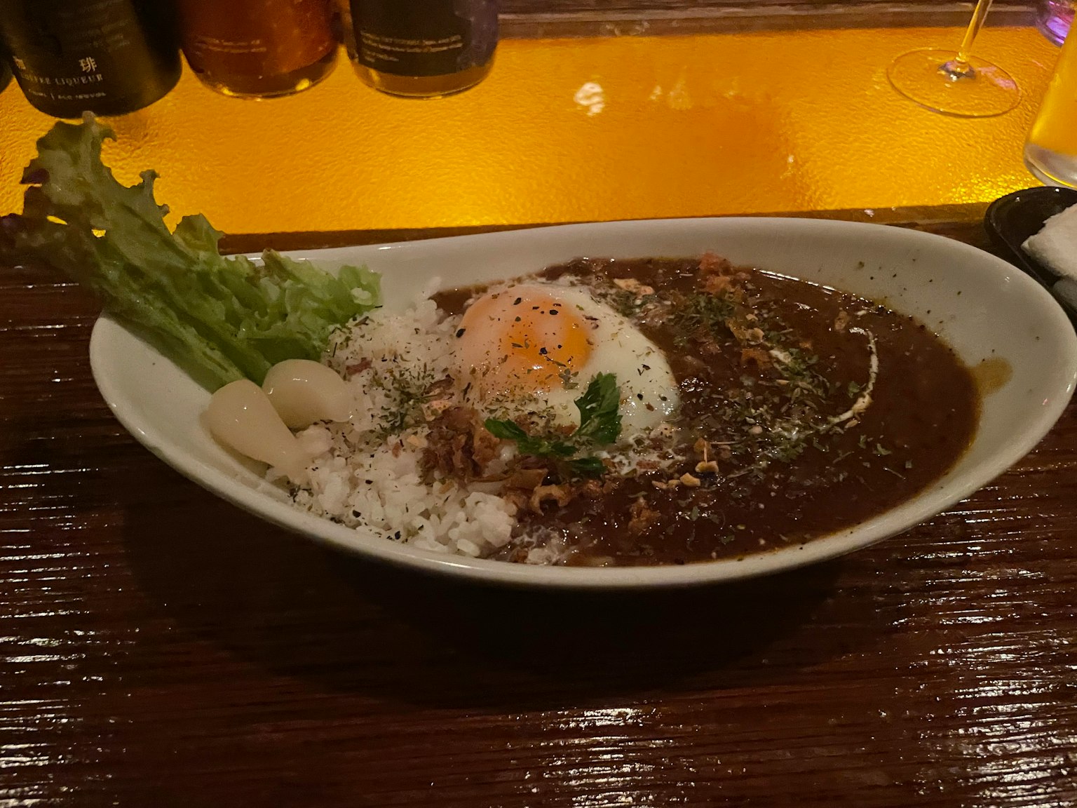 盤子裡的日本咖哩飯 上面放著一顆半熟蛋和生菜