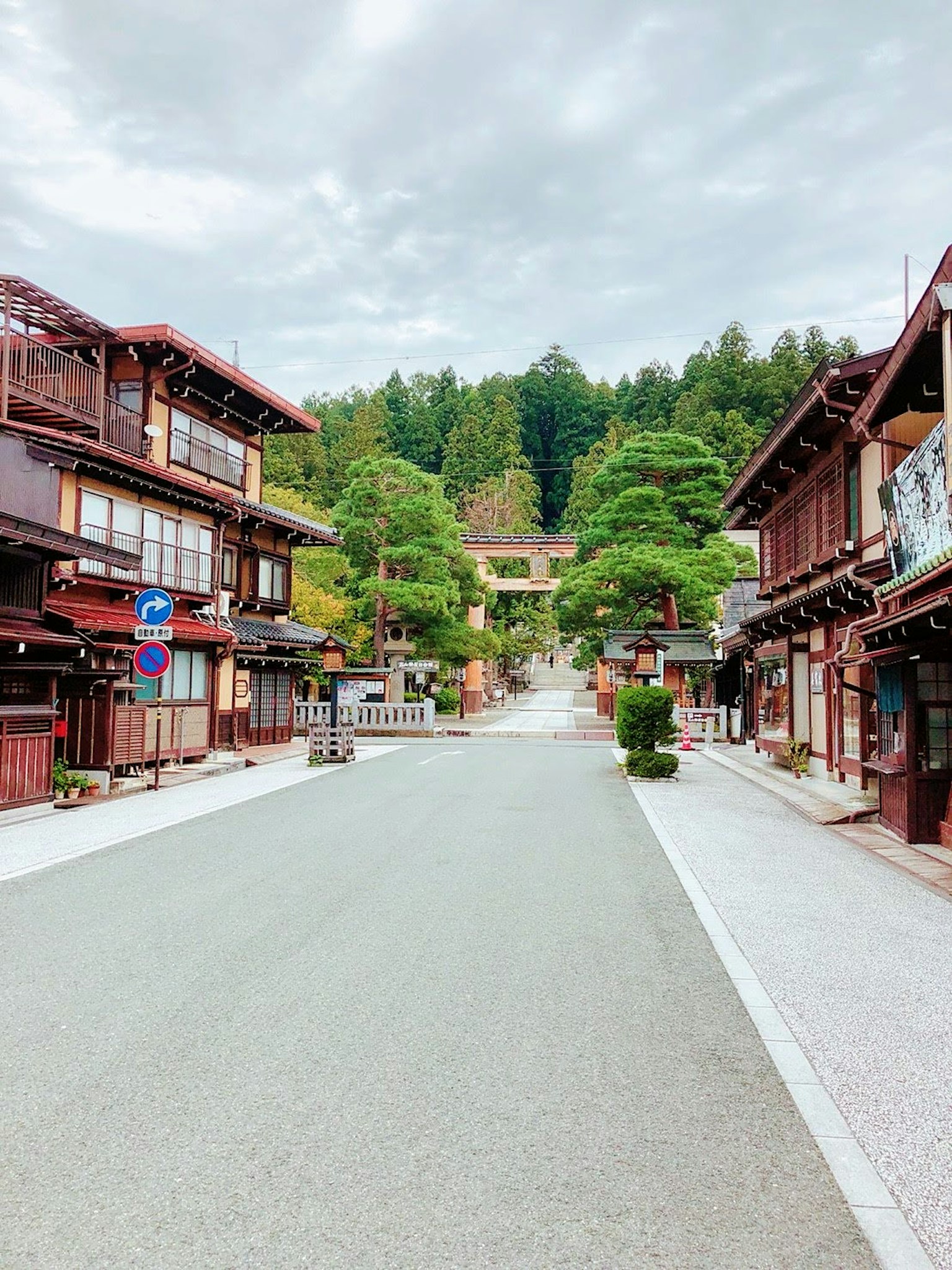 조용한 거리와 푸른 산이 배경인 전통 일본 건물들
