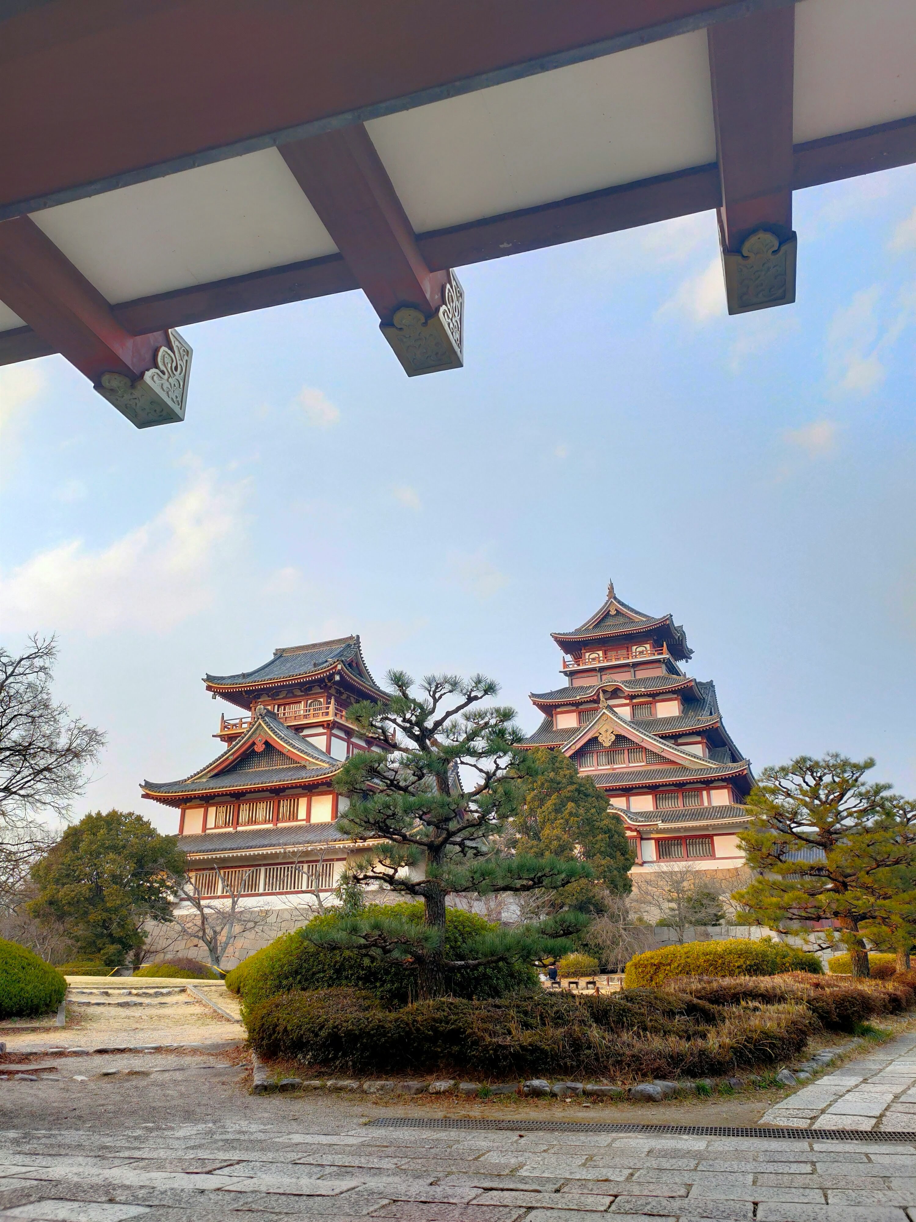 朱色の寺院建築と庭園の石畳