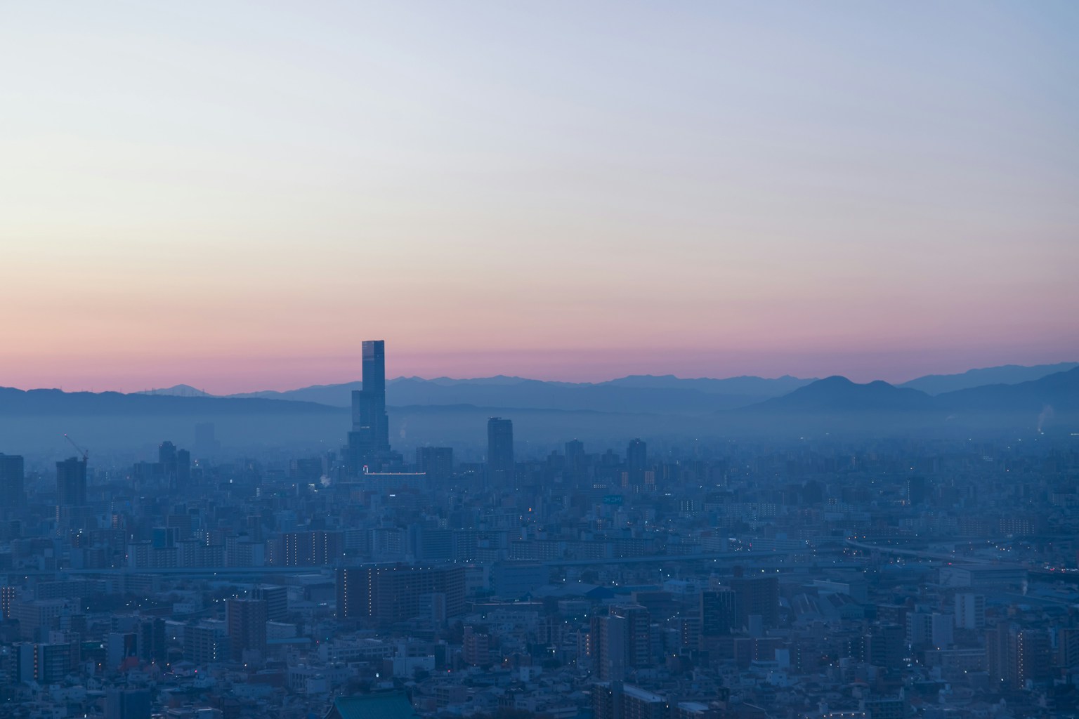 都市のスカイラインと薄明かりの空が広がる風景
