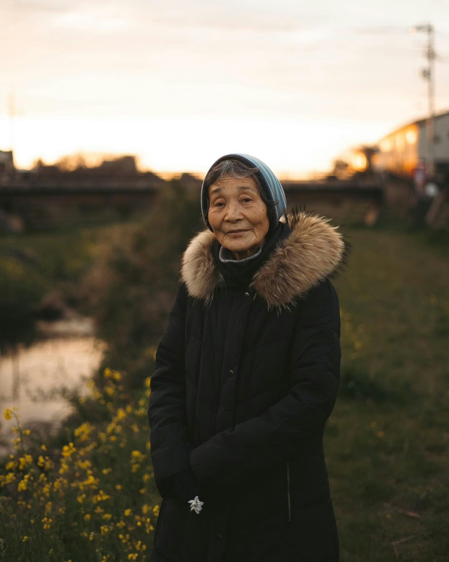 夕暮れの川沿いで微笑む女性