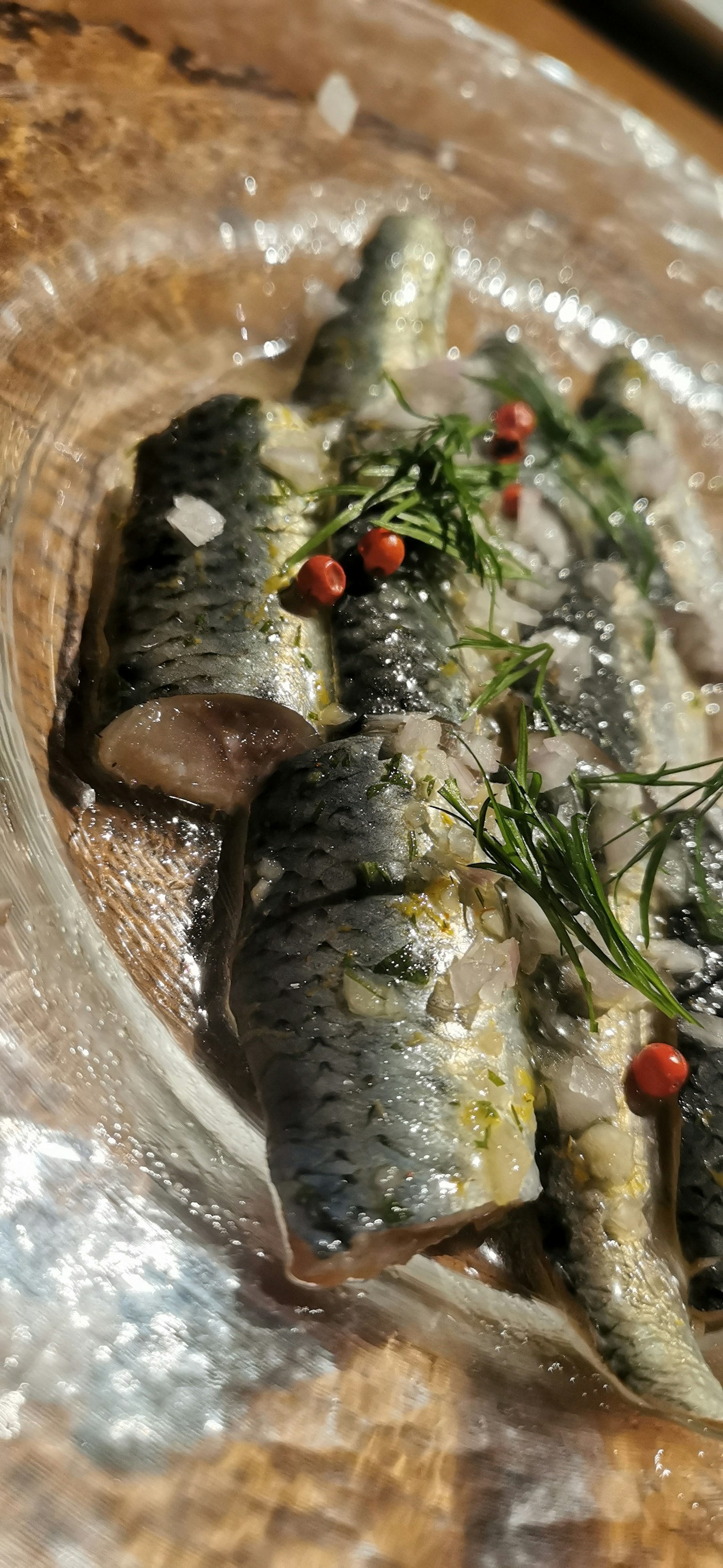 盤子裡裝飾著紅色漿果和香草的烤魚