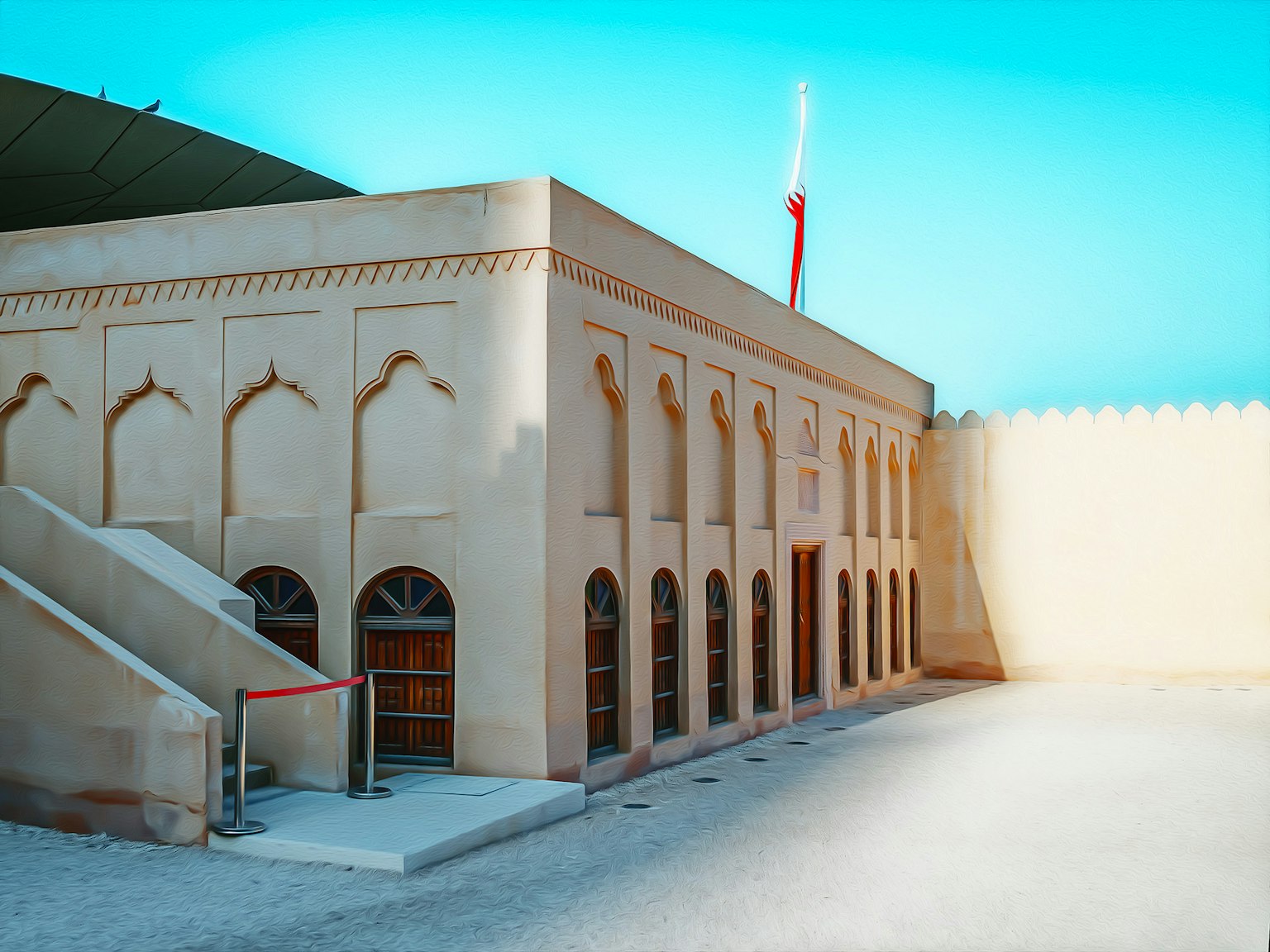 L'image présente un bâtiment avec des éléments architecturaux arabes L'extérieur est de couleur claire avec des fenêtres décoratives et un espace environnant spacieux