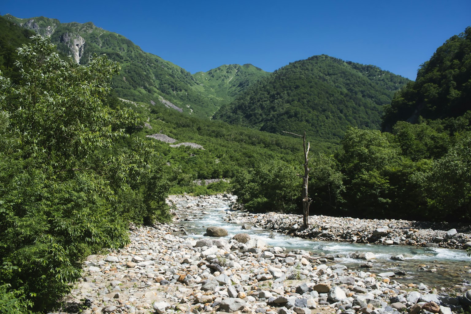 Un ruisseau clair entouré de montagnes et de rives rocheuses
