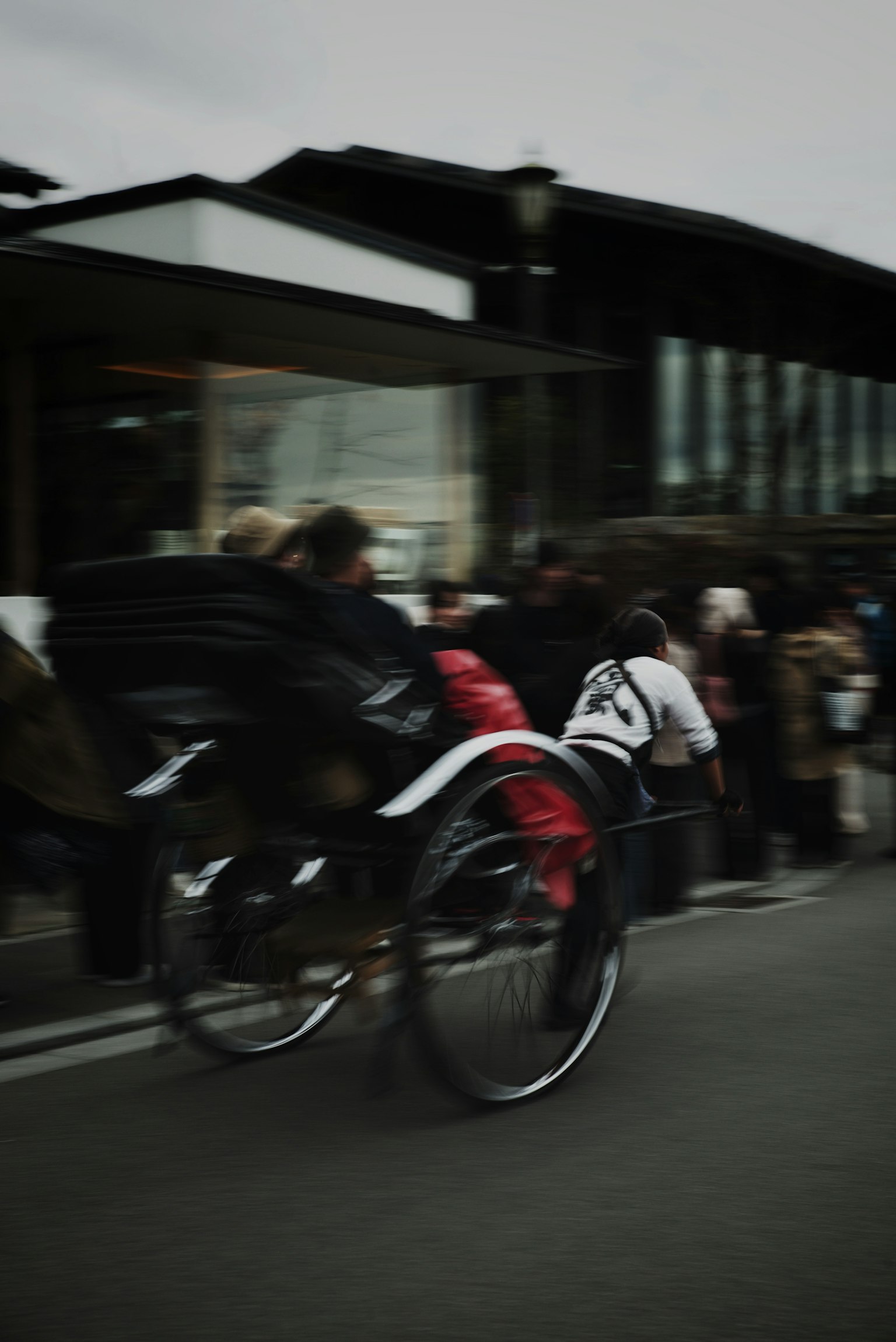 Rickshaw en mouvement avec des gens dans une file dans un cadre urbain