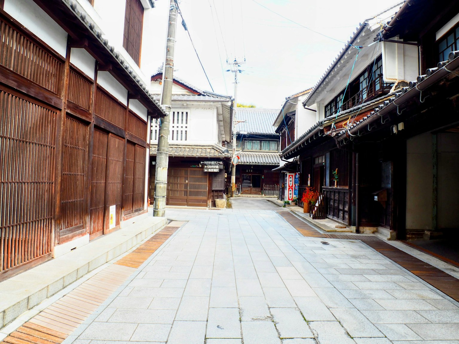 Quiet street scene featuring traditional wooden buildings and stone pavement
