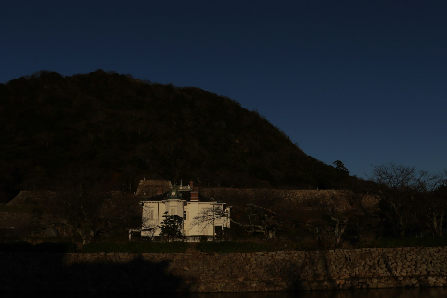 黑暗背景下的白色建築和山的輪廓