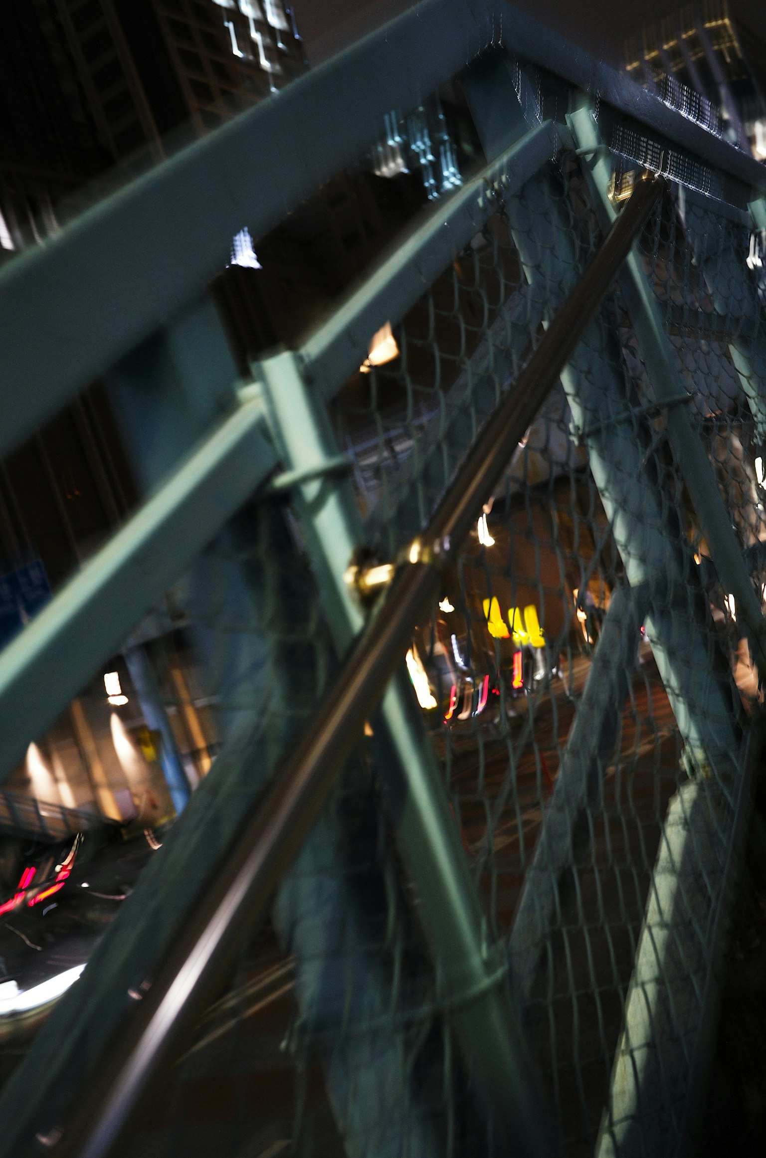 Primer plano de la barandilla y red de un puente en un paisaje urbano nocturno