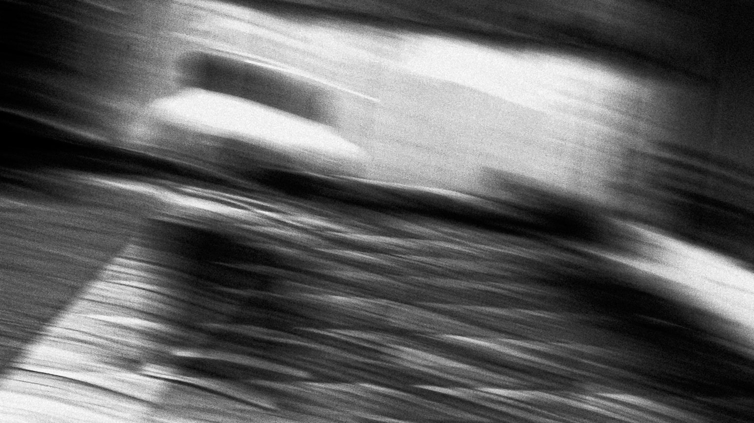 Imagen abstracta borrosa en blanco y negro con líneas y formas dinámicas