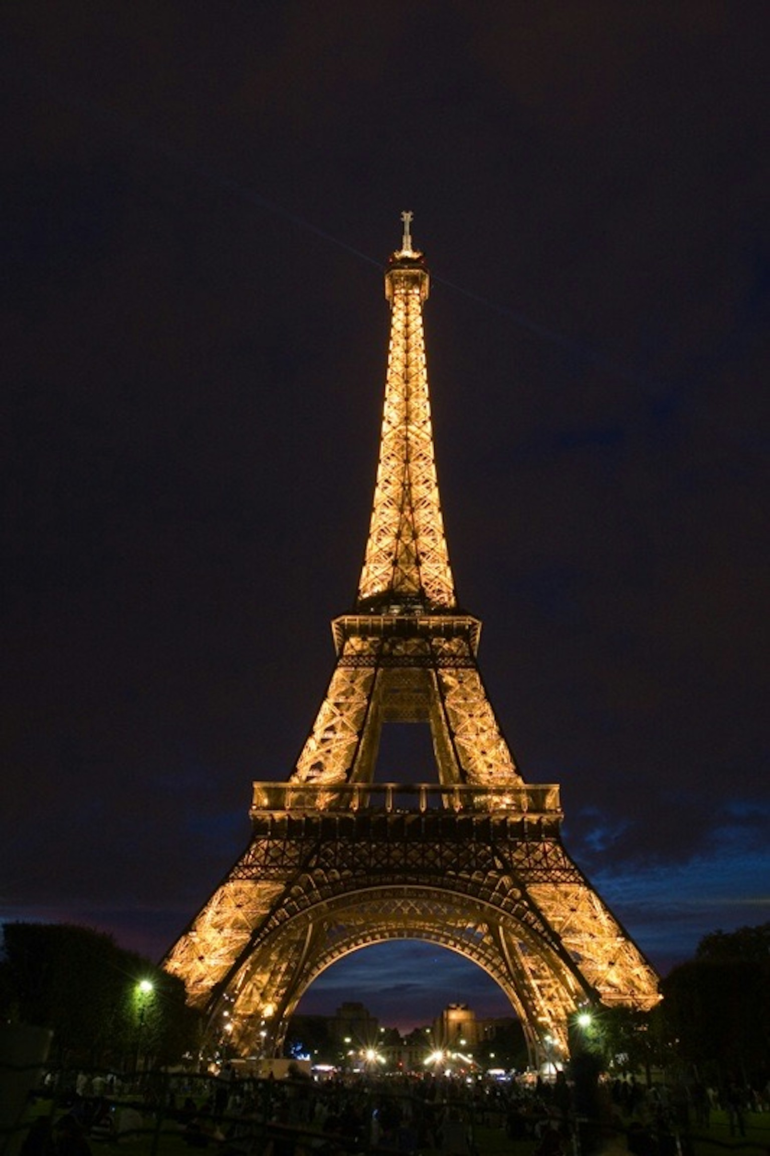 Torre Eiffel iluminada por la noche con cielo oscuro