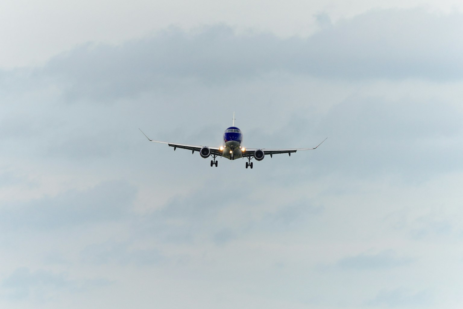 Avion atterrissant sur un fond de ciel nuageux