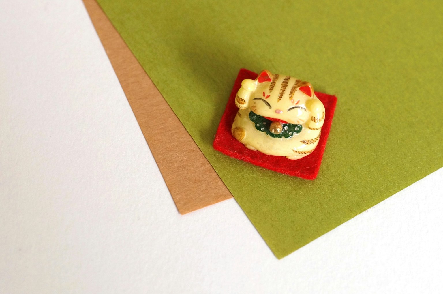 Cat figurine placed on green and brown paper