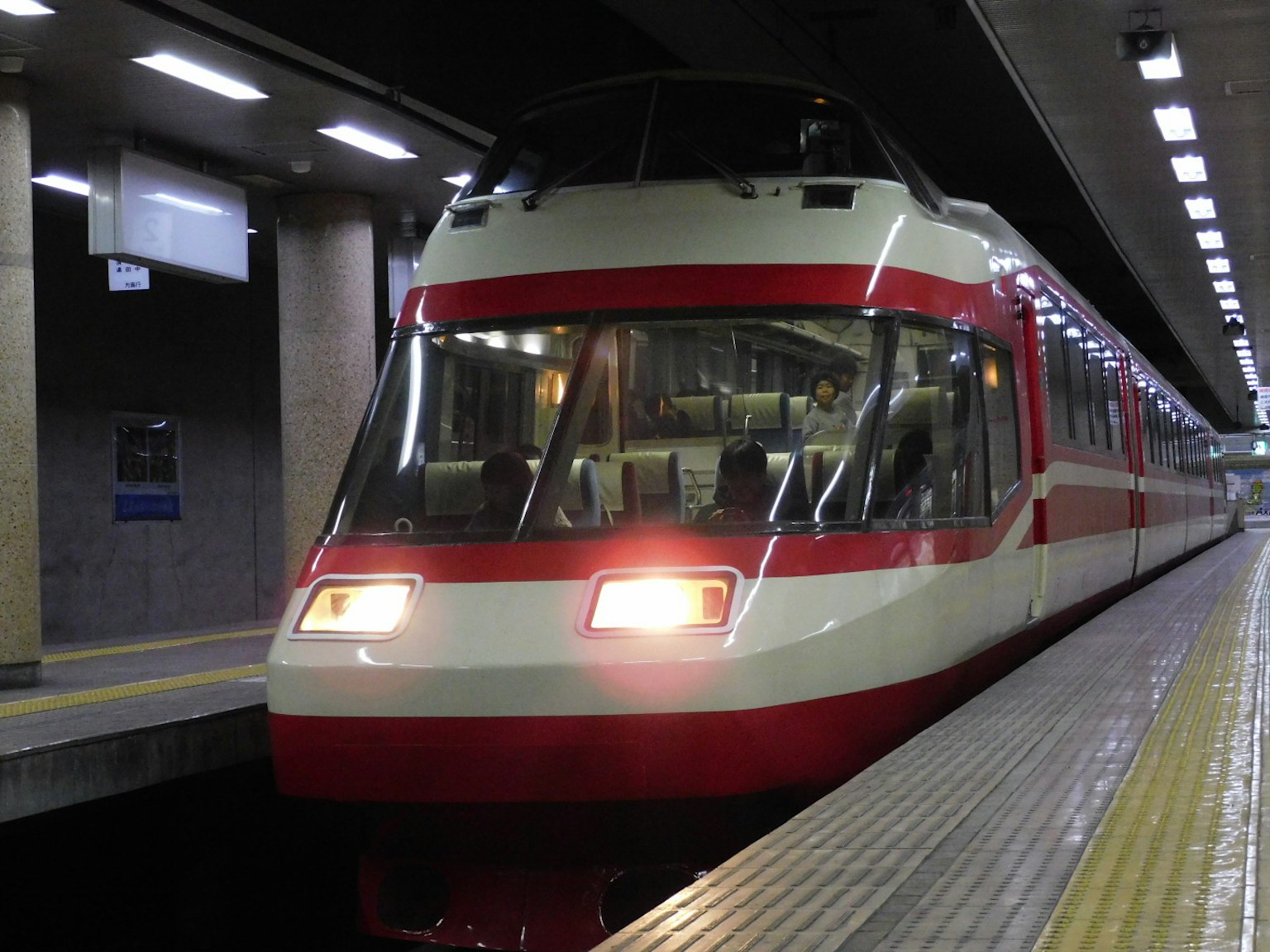 รถไฟสีแดงและขาวจอดอยู่ที่ชานชาลารถไฟฟ้า