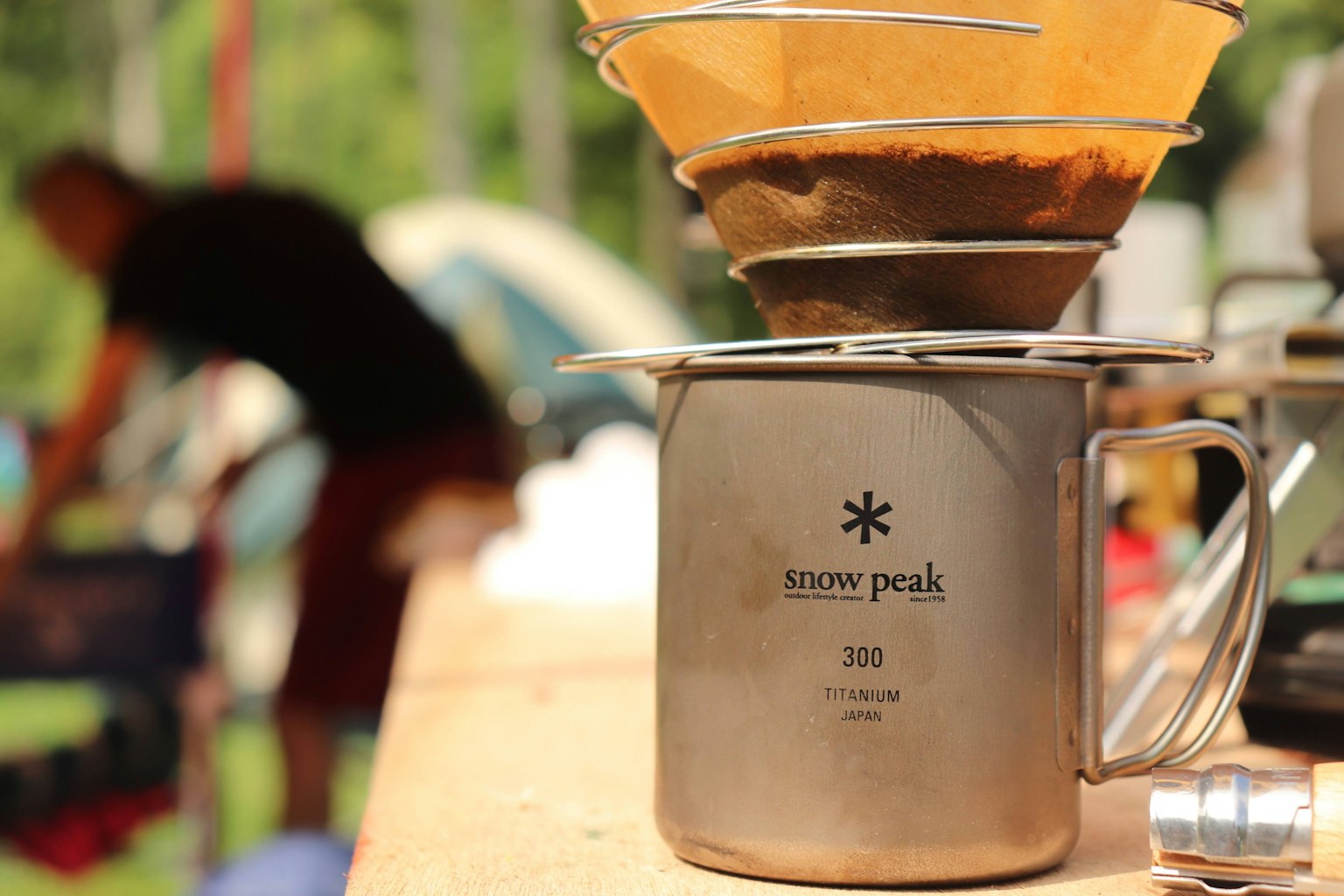 Equipo de preparación de café de acero inoxidable en una mesa de camping