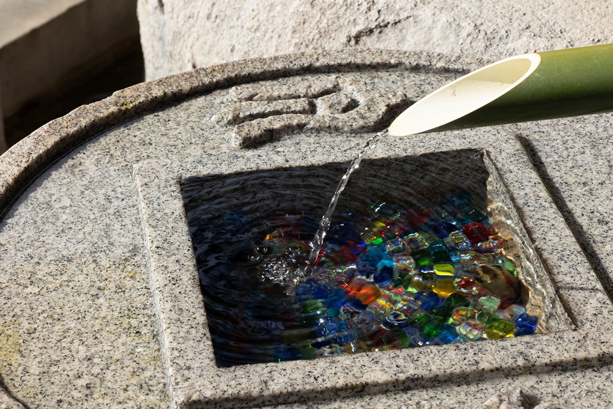 岡寺の手水鉢に注がれる水と色ガラスの玉