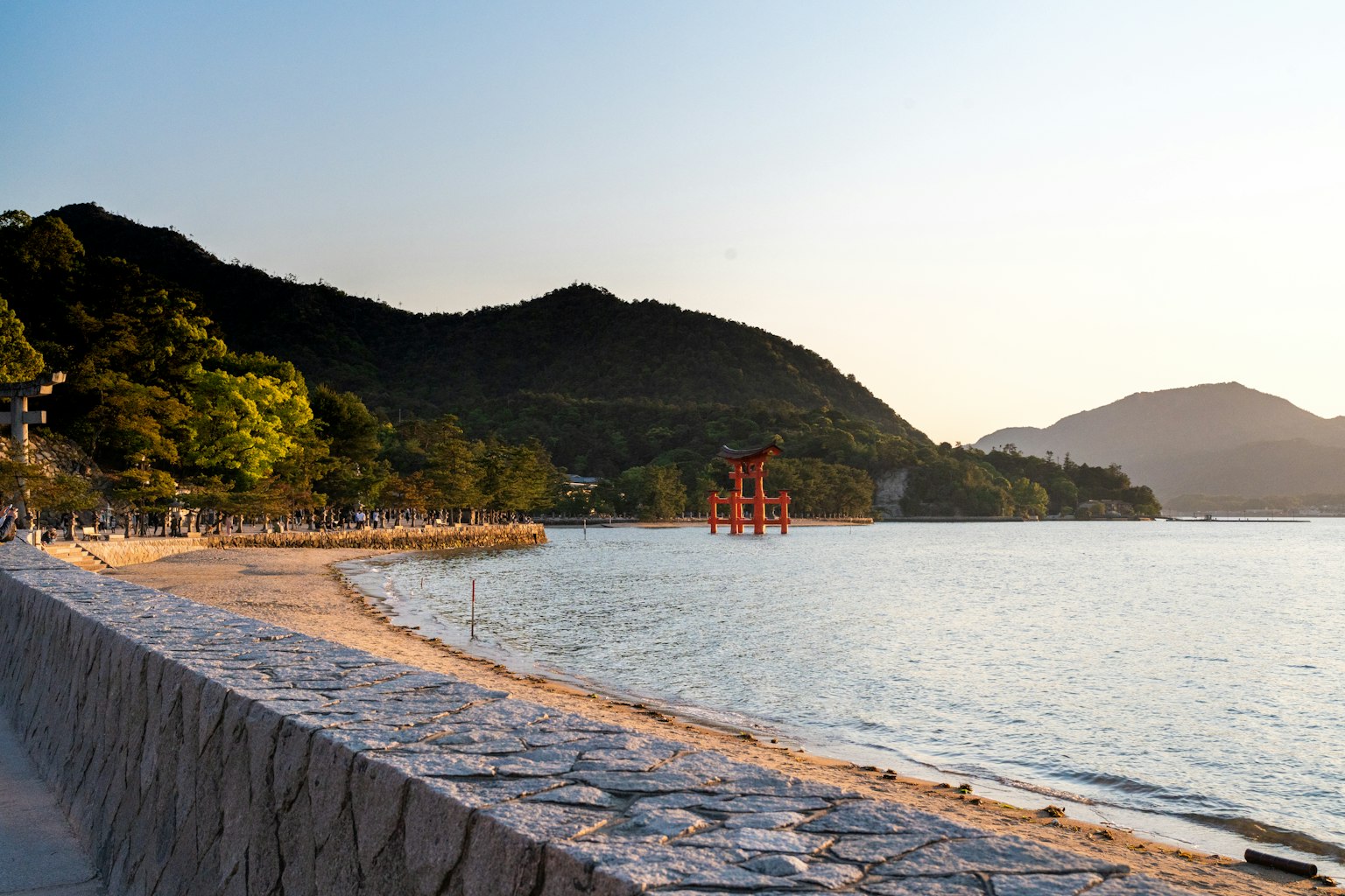 Vista panoramica della spiaggia al tramonto con costa e montagne
