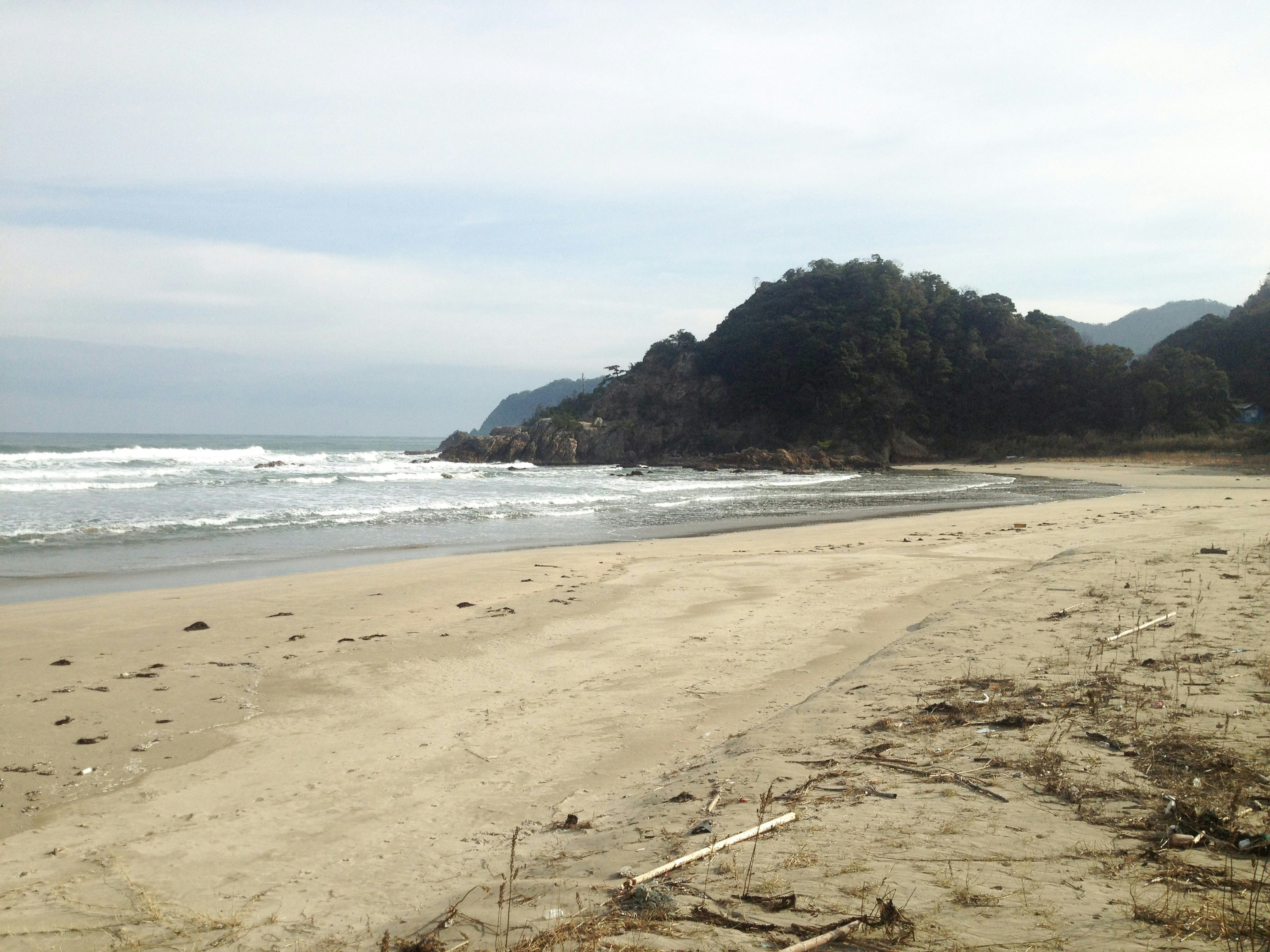 沙滩海岸线与海浪及岩石岬角景观