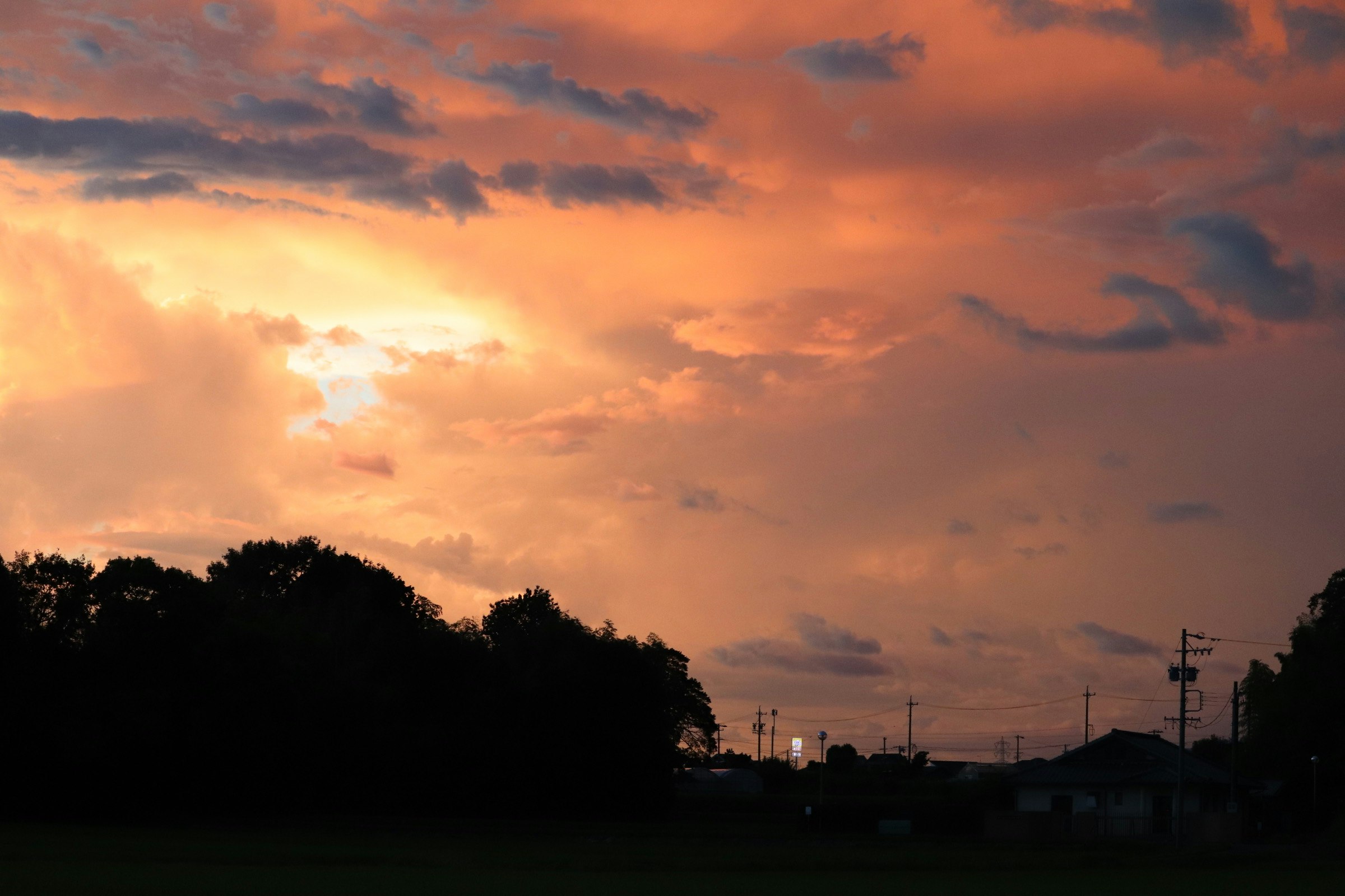 clouds over a sunset sky with a silhouetted townscape