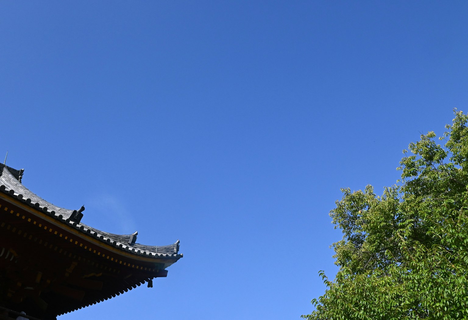 Langit biru jernih dengan atap bangunan tradisional