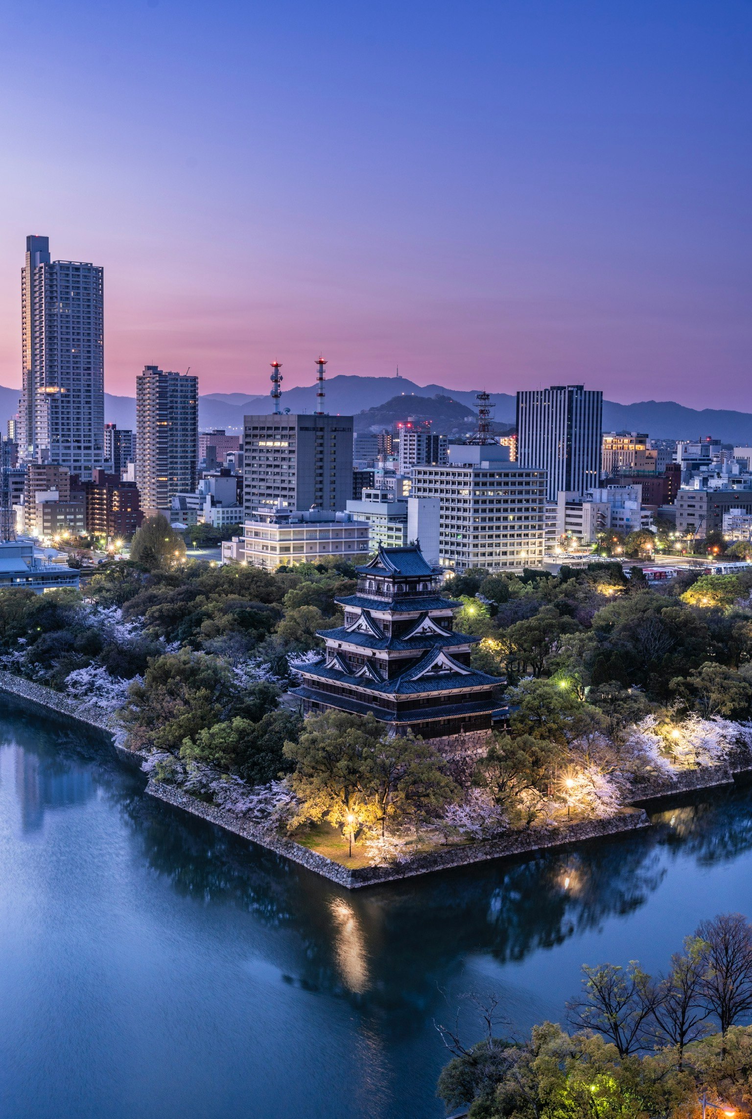 Castillo de Hiroshima al amanecer con un horizonte moderno