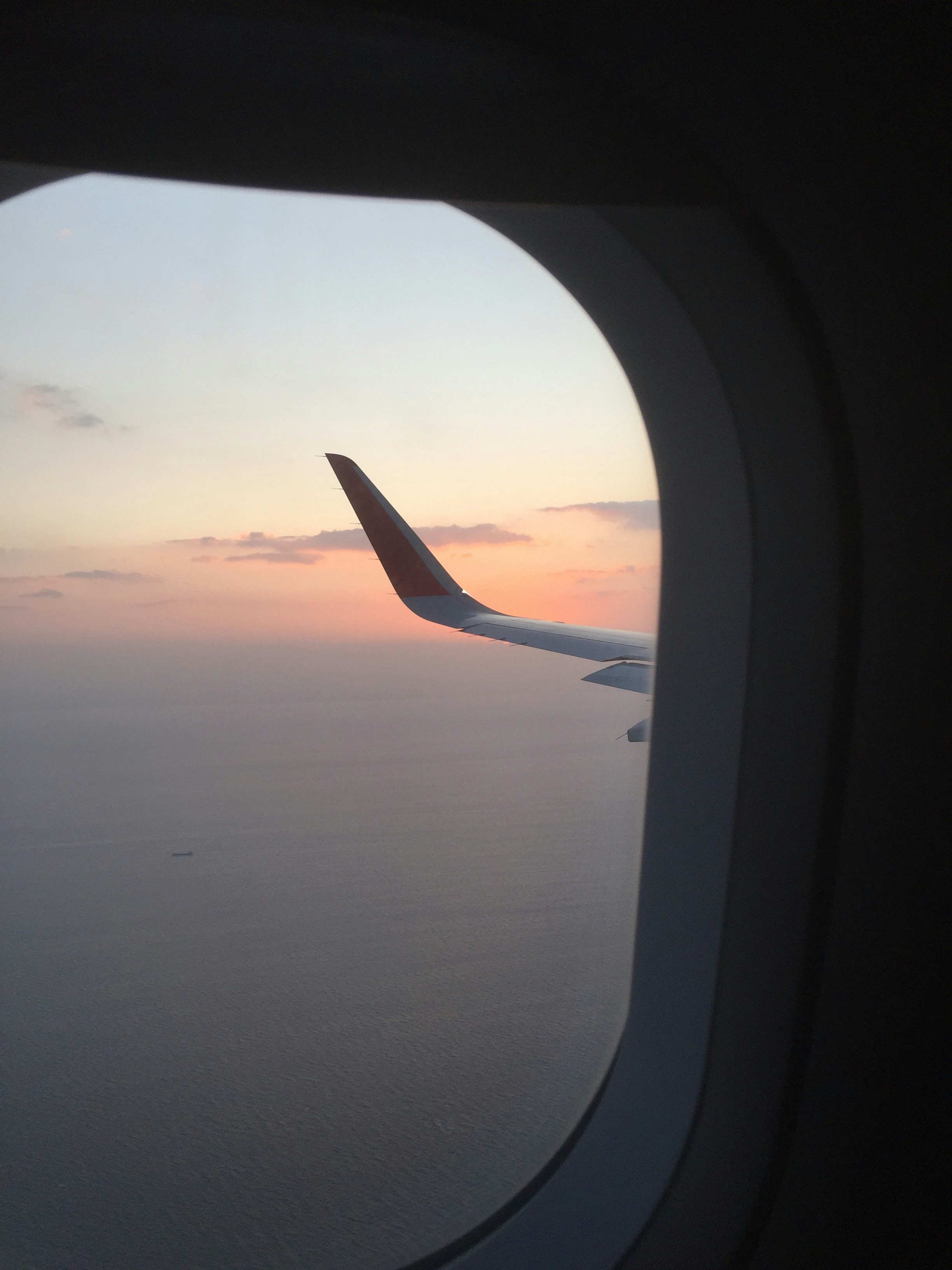 從飛機窗戶看見的夕陽與機翼