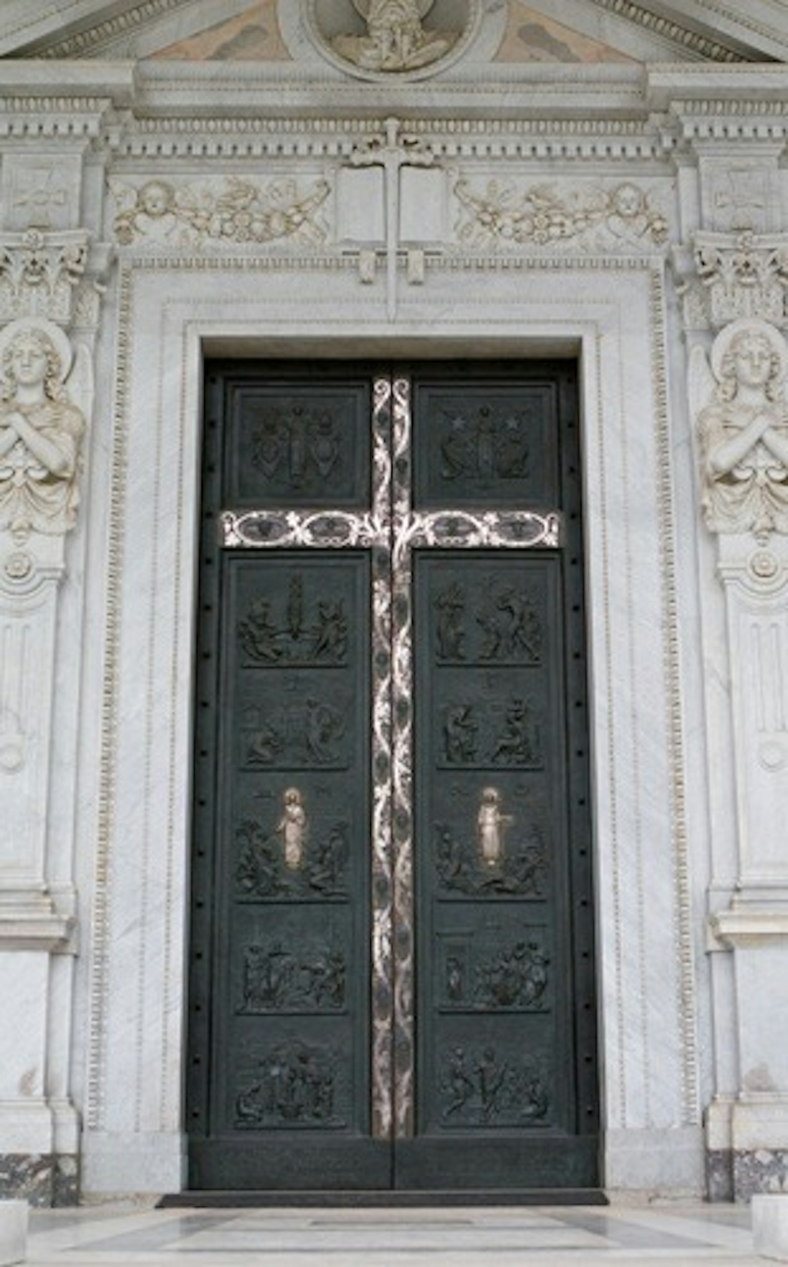 Porte verte avec croix ornée et motifs sculptés