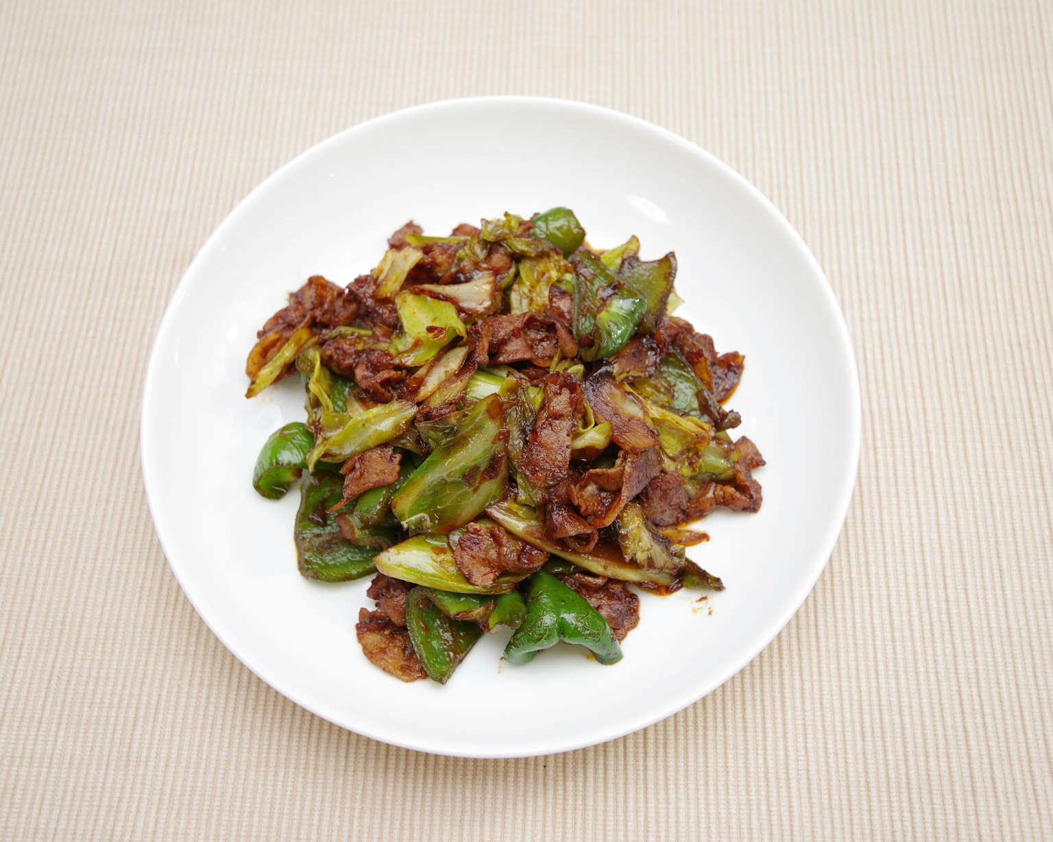 Viande et légumes sautés dans une assiette blanche