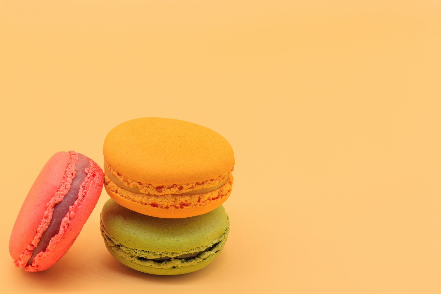 Macaron nhiều màu xếp chồng trên nền cam