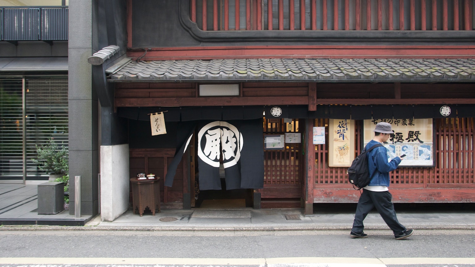 Scène de rue avec l'entrée d'un bâtiment japonais traditionnel et un rideau noren noir
