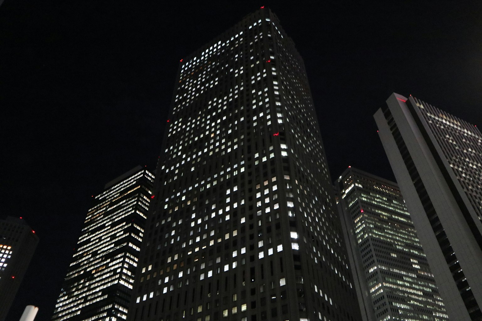 Paesaggio urbano notturno con grattacieli illuminati da finestre luminose